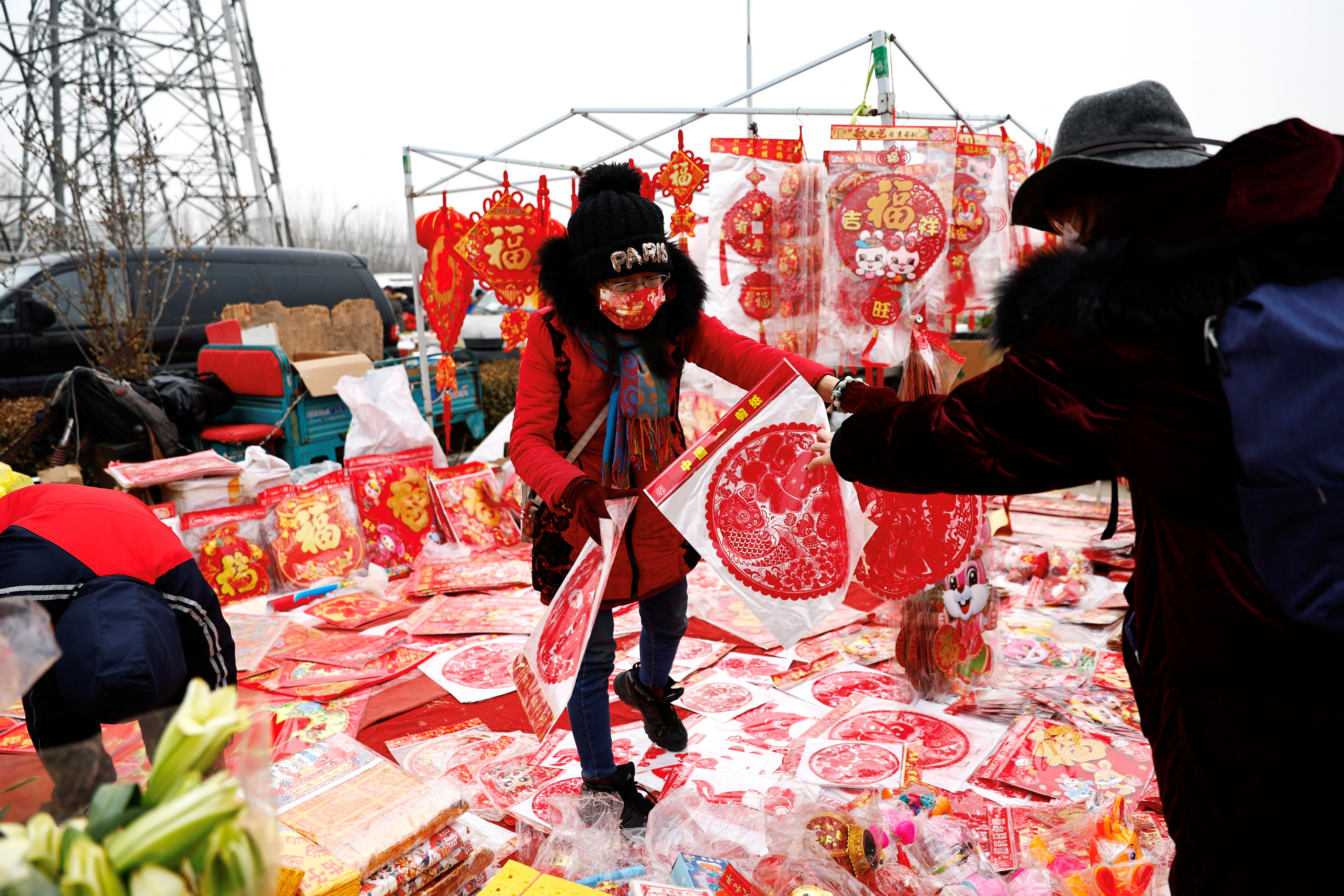 Vendor sells Chinese Lunar New Year decorations at an outdoor market in Beijing