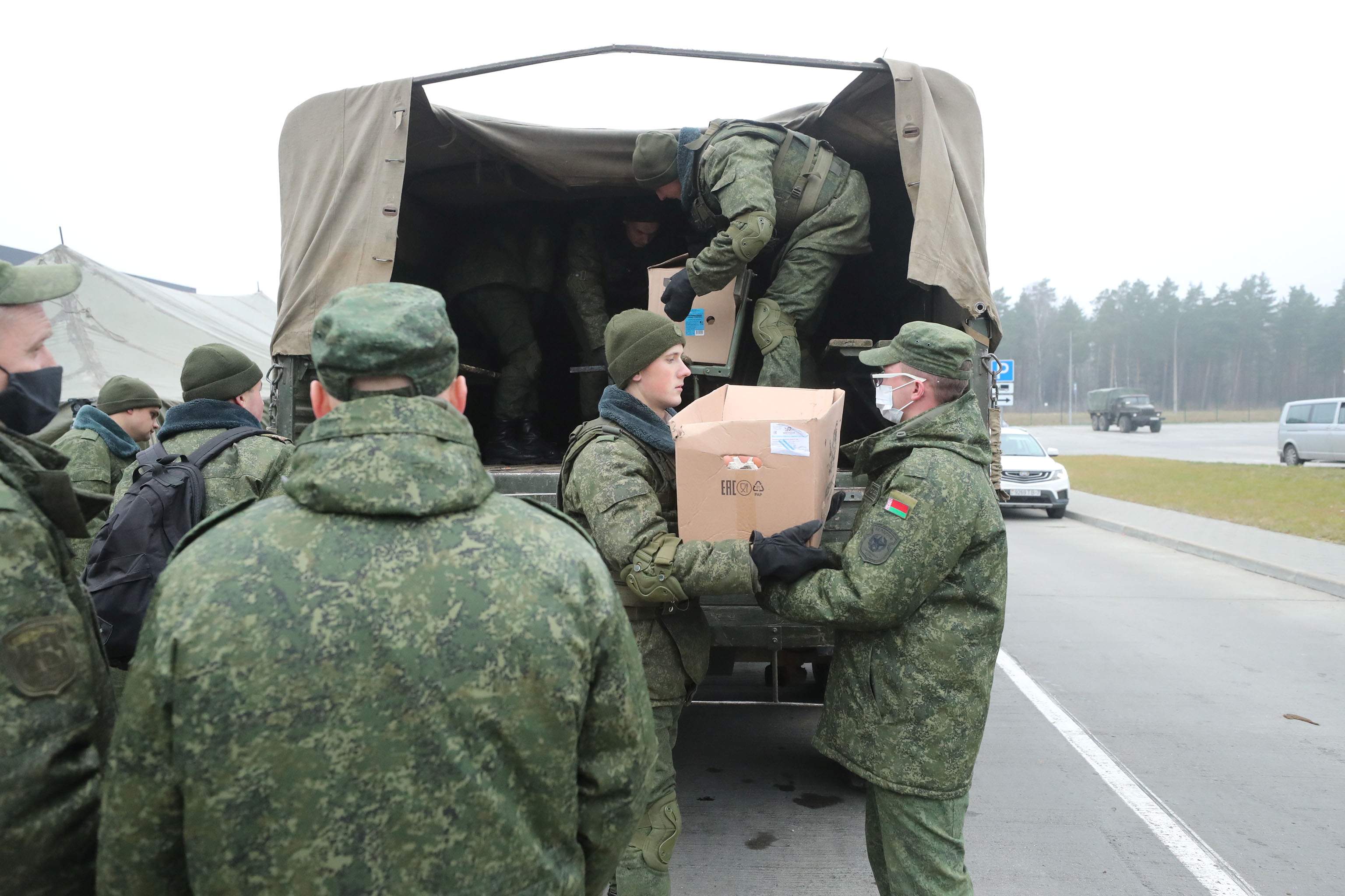 Belarusian service members unload a truck with humanitarian aid during its distribution near Bruzgi - Kuznica checkpoint on the Belarusian-Polish border in the Grodno region, Belarus November 17, 2021. Leonid Scheglov/BelTA/Handout via REUTERS  