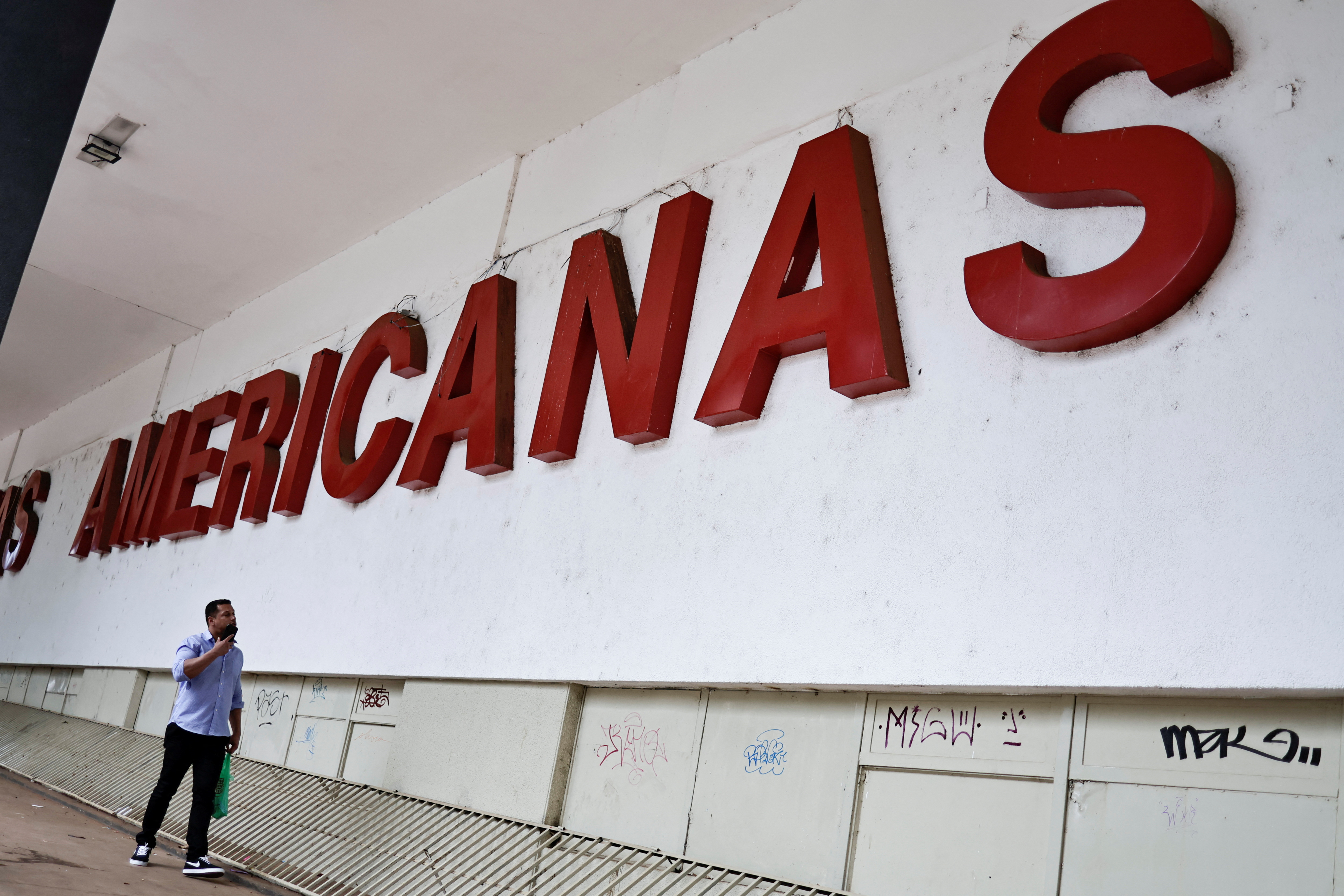 A man walks in front of a Lojas Americanas store in Brasilia