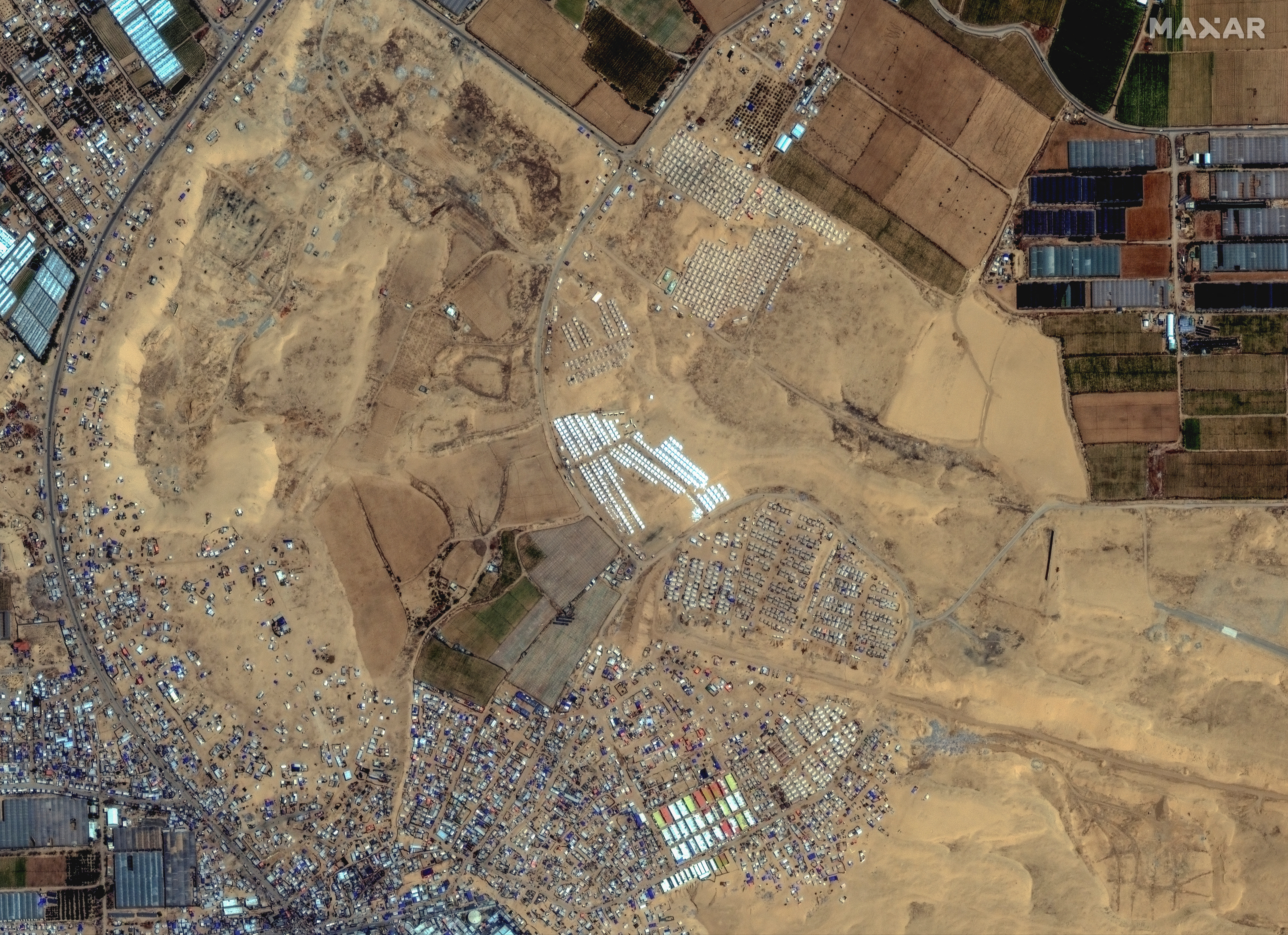 A satellite image shows an overview of a tent camp settlement near Rafah