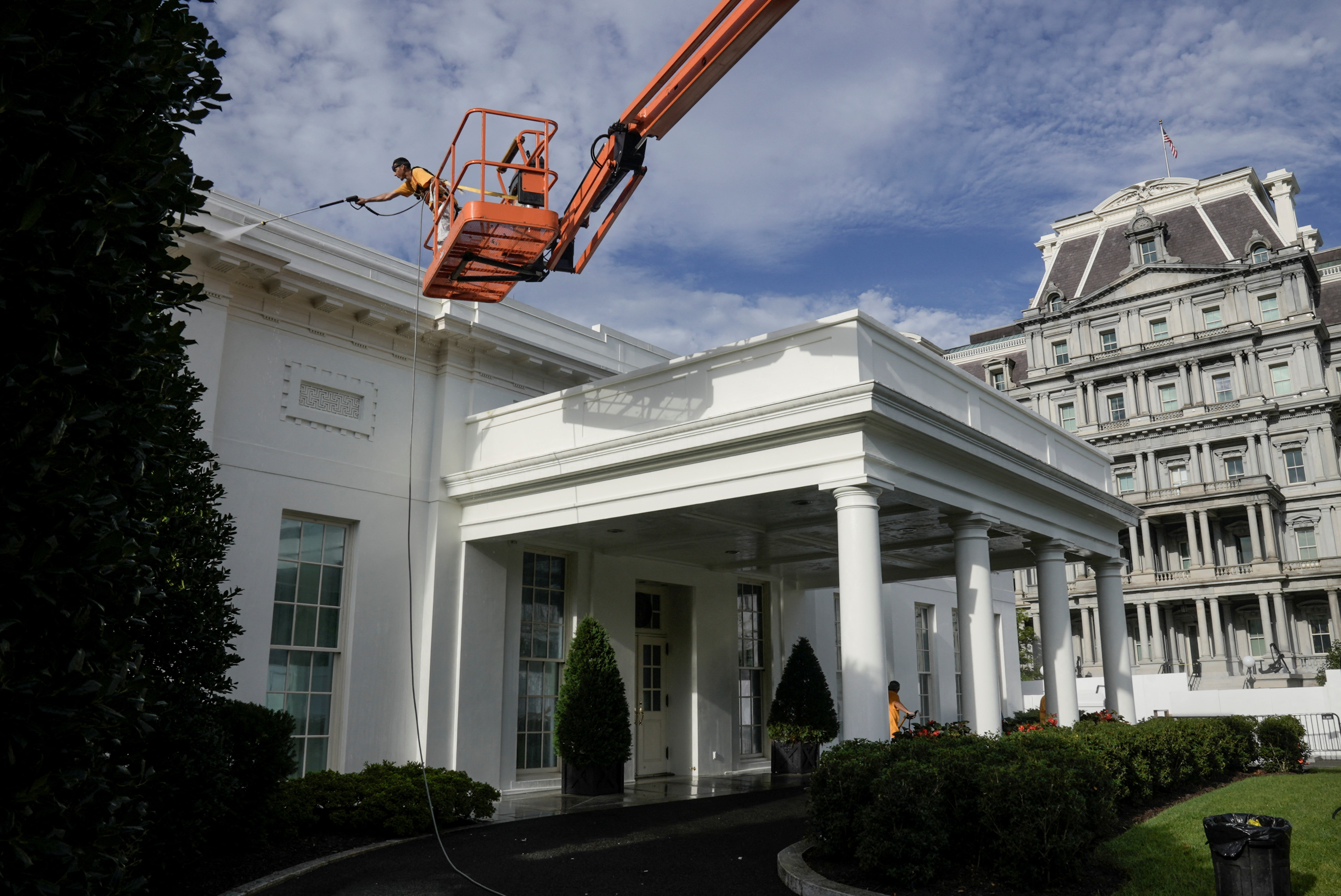 Workers clean the White House with high-pressure hoses, in Washington