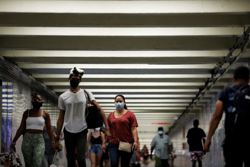 People wear masks as they pass through a pedestrian subway as cases of the infectious coronavirus Delta variant continue to rise in New York City, New York