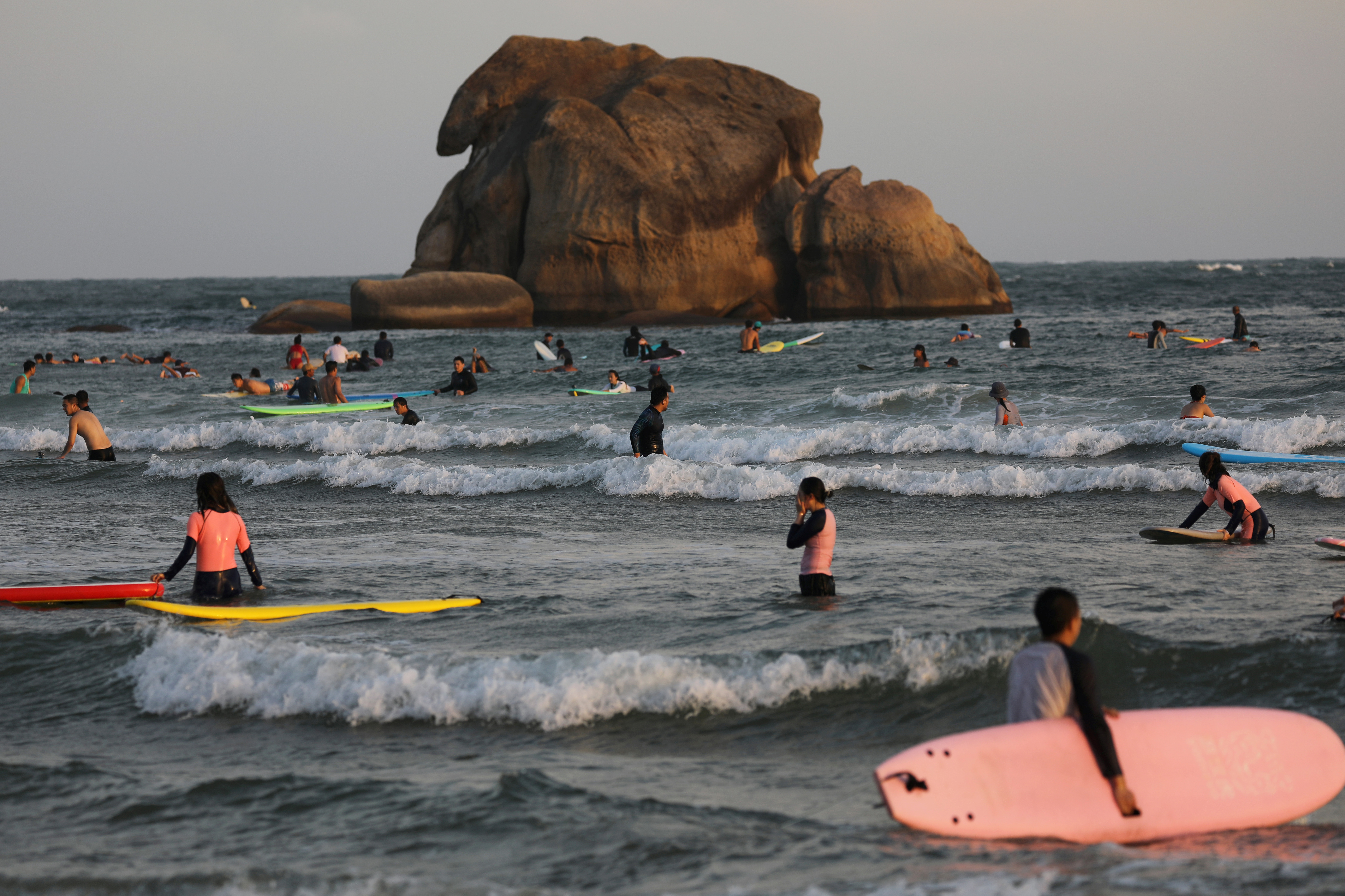 Surfers are seen in the sea in Sanya
