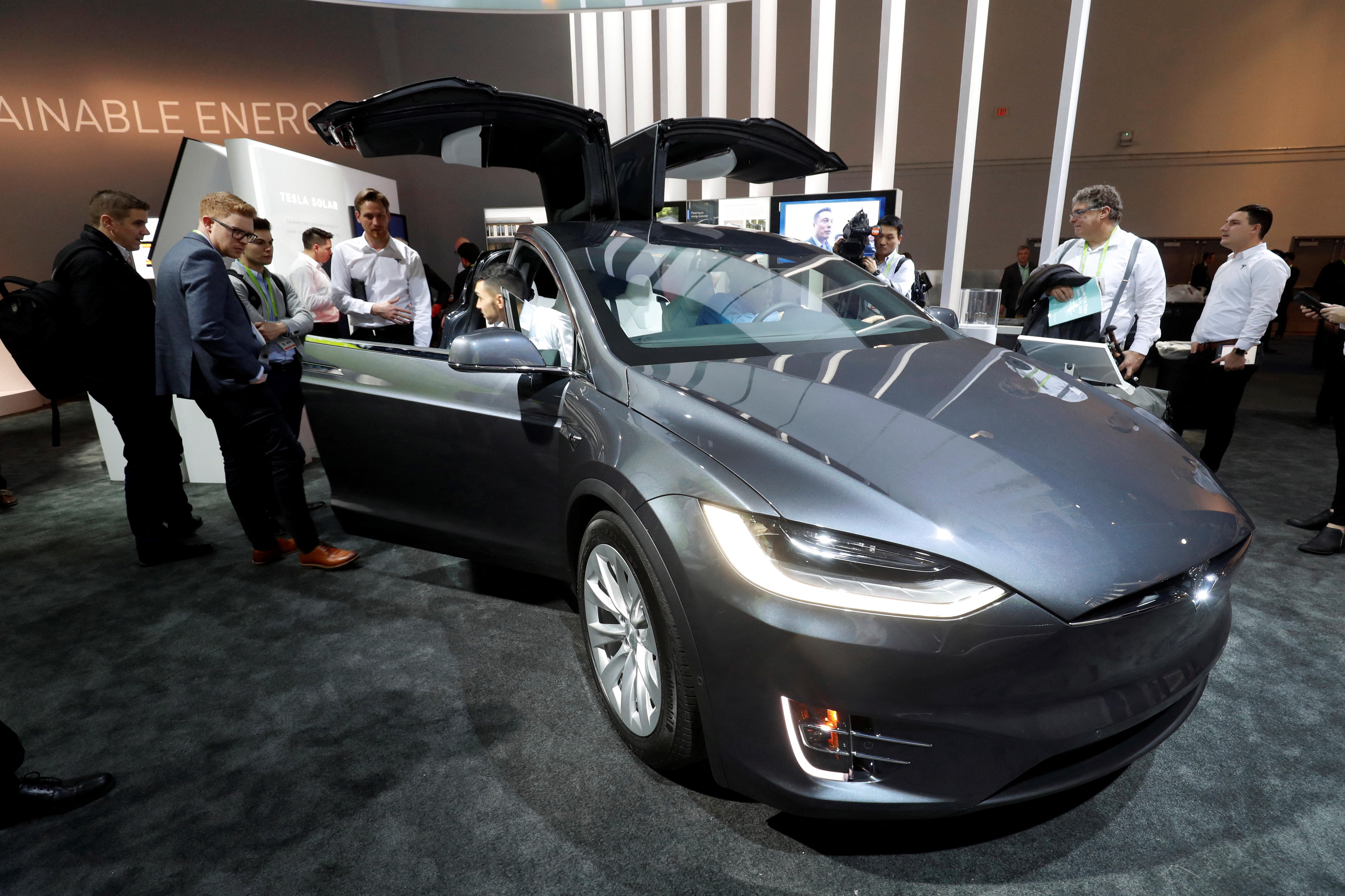 Attendees look over a Tesla Model X powered by Panasonic batteries at the Las Vegas Convention Center during the 2018 CES in Las Vegas