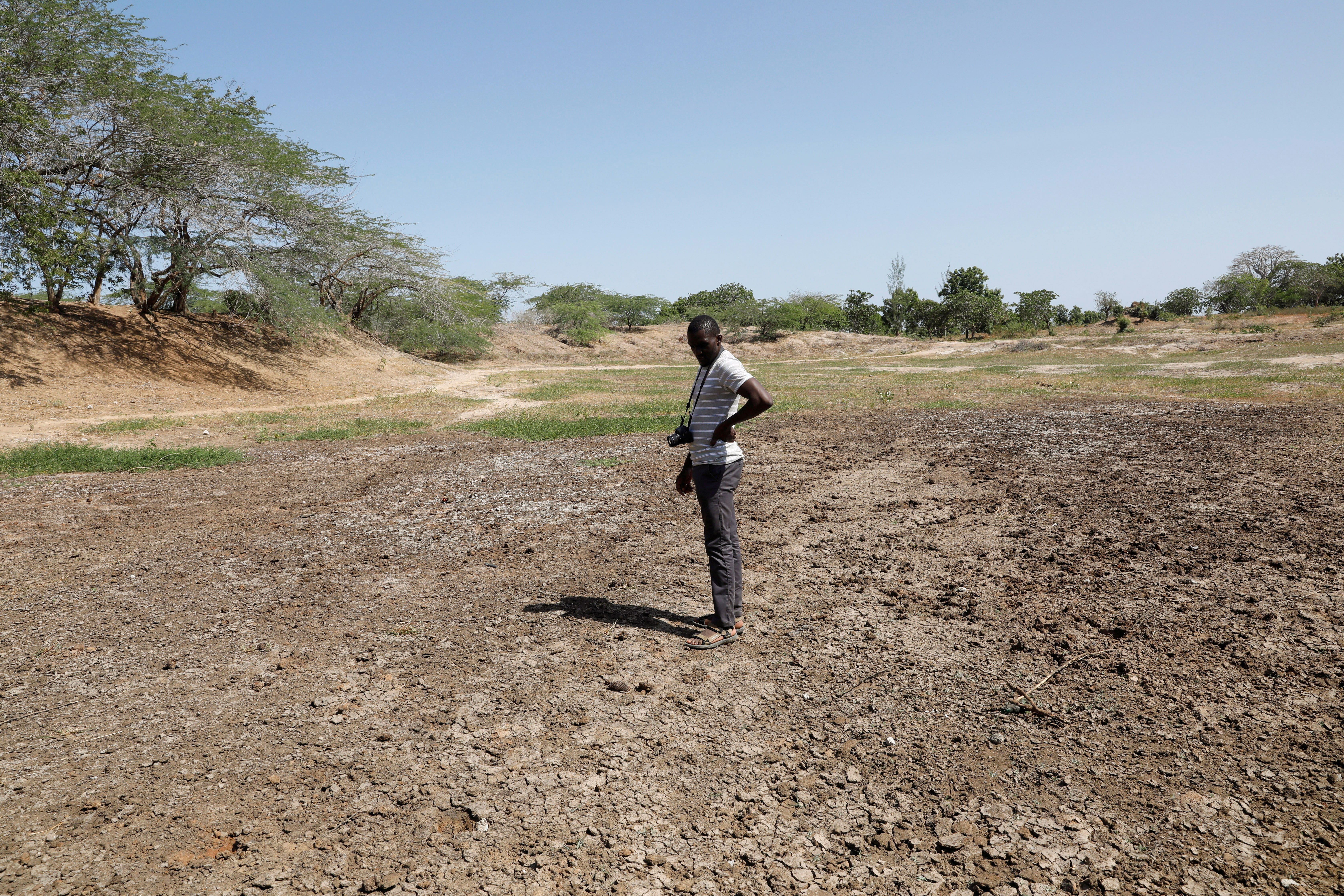 FEWS NET scientist Chris Shitote examines a dry water hole in Kilifi county