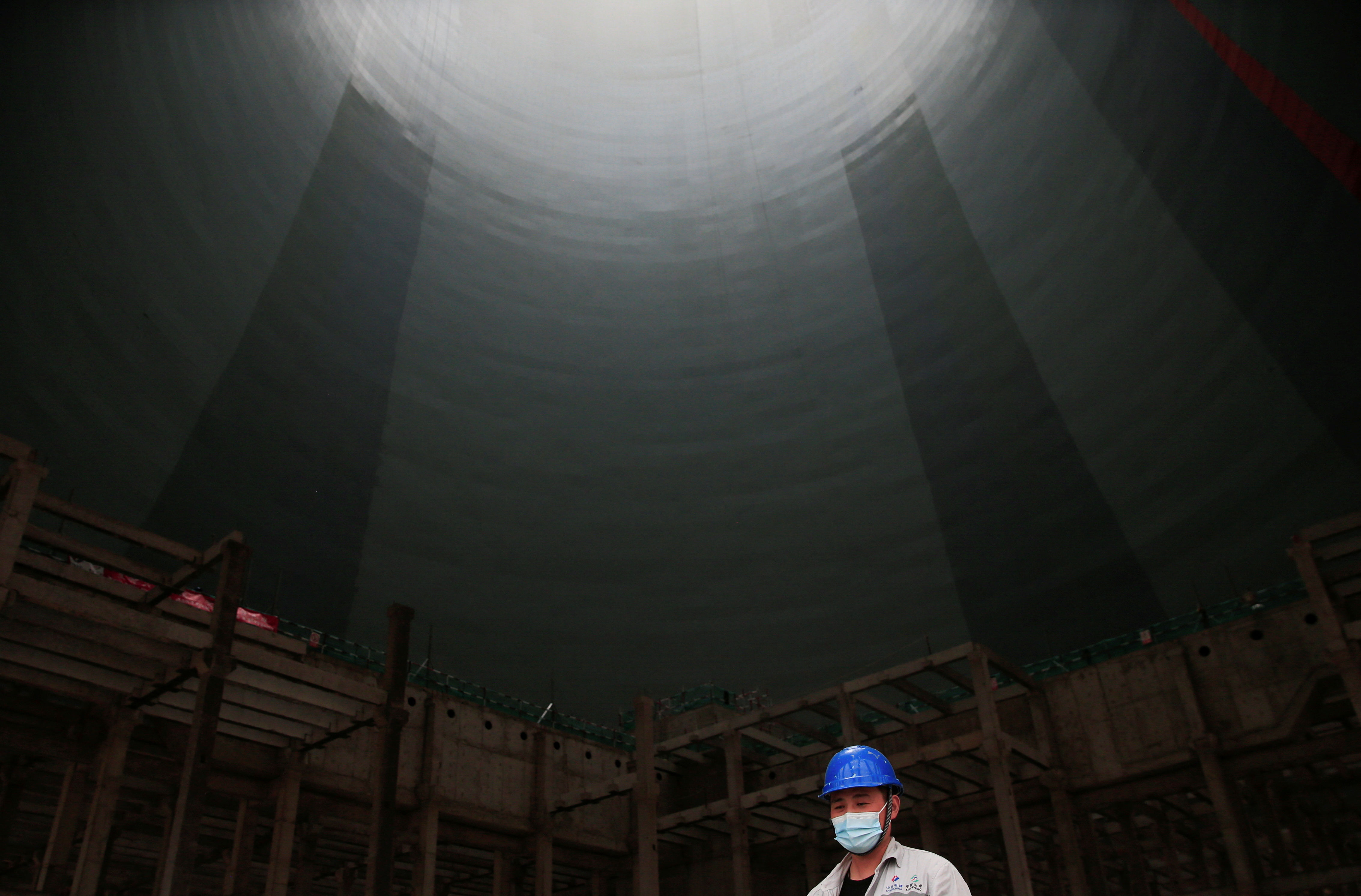 Worker walks beneath a cooling tower at Hwange Power station's Phase 8, in Hwange