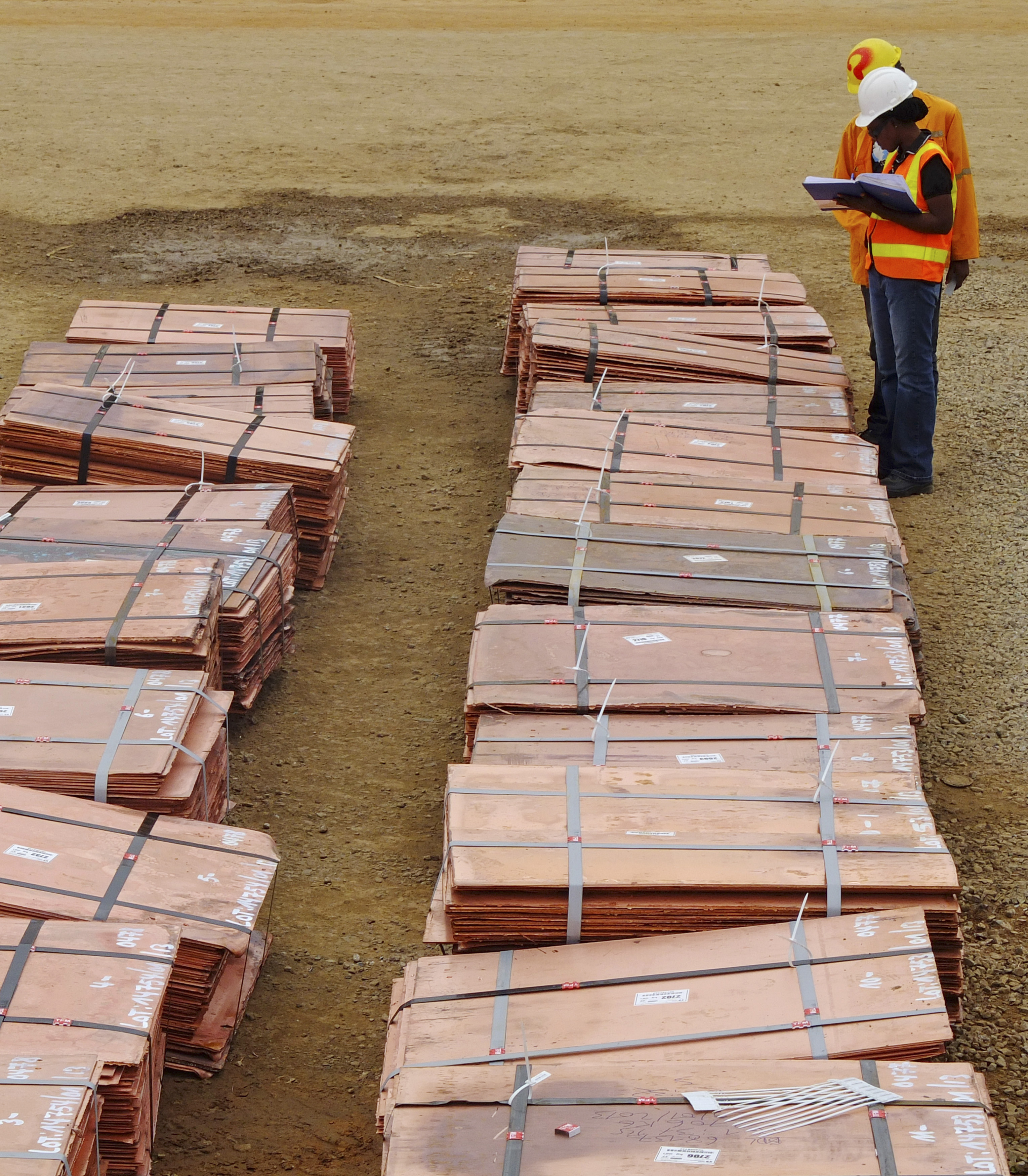 Workers at Tenke Fungurume, a copper mine in the southern Congolese province of Katanga, check bundles of copper cathode sheets ready to be loaded and sent out to buyers