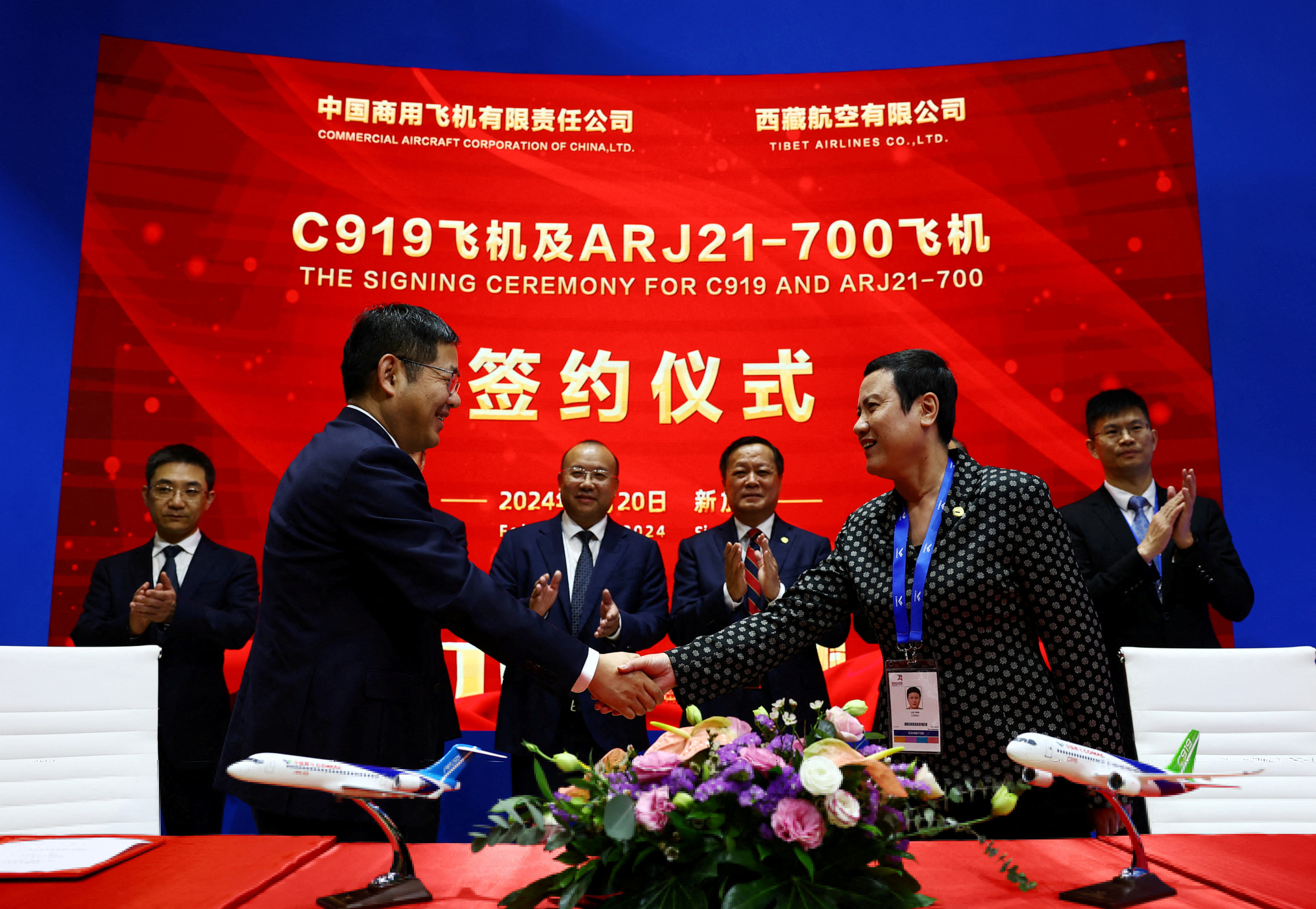 Comac's Chairman He Dongfeng witnesses a signing ceremony between Comac and Tibet Airlines during the Singapore Airshow at Changi Exhibition Centre in Singapore