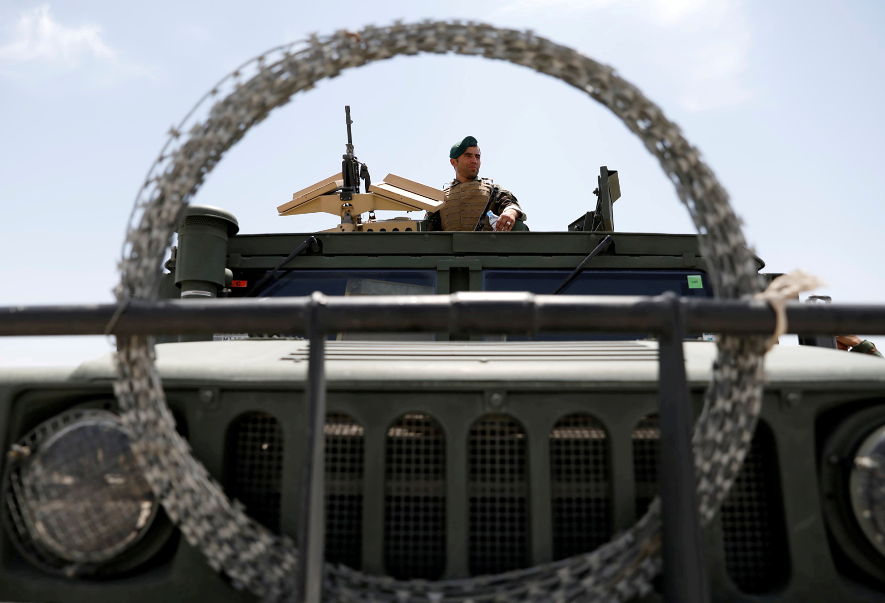 An Afghan security forces member keeps watch as he sits in an army vehicle in Bagram U.S. air base, after American troops vacated it, in Parwan province
