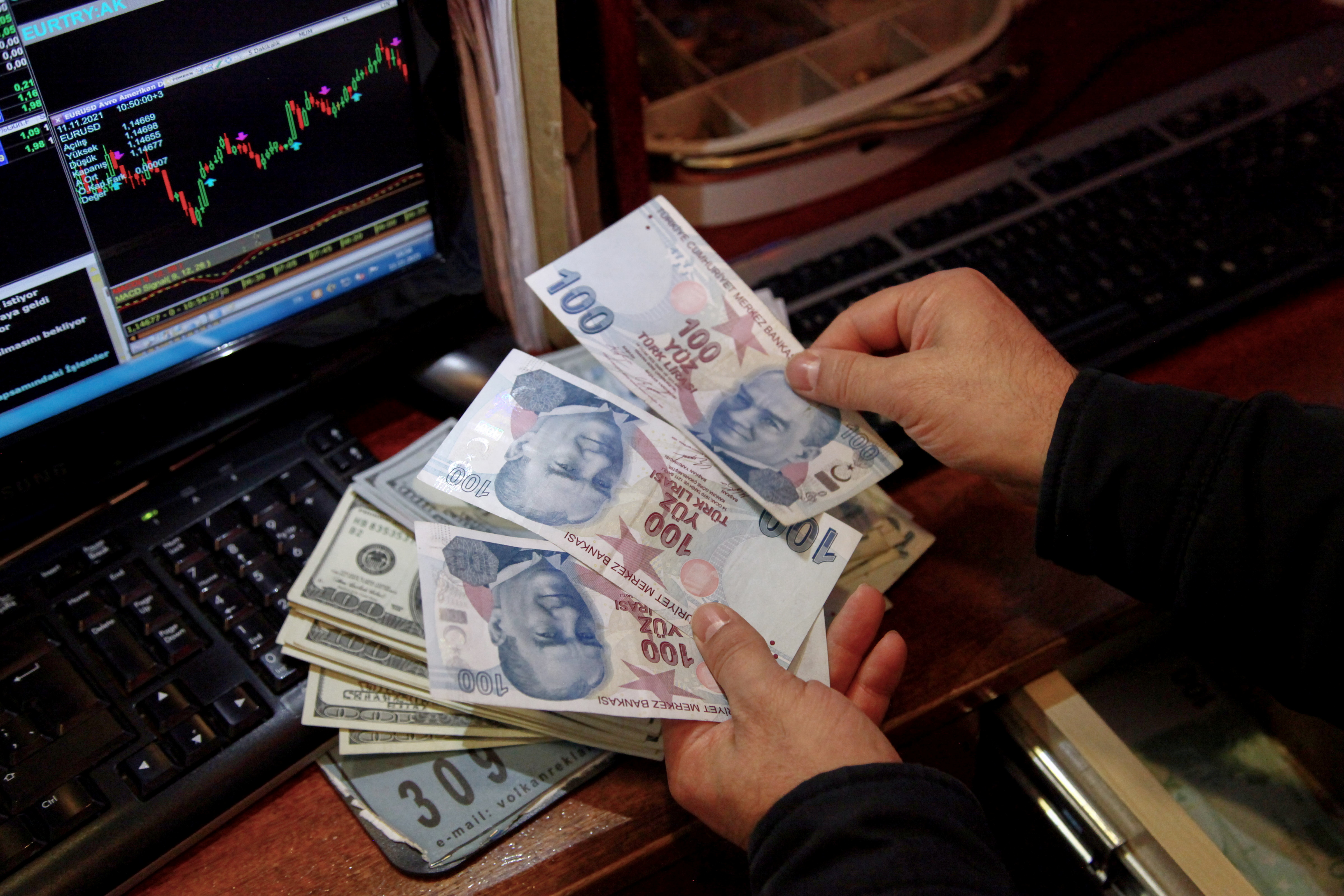A money changer counts Turkish lira banknotes at a currency exchange office in Ankara