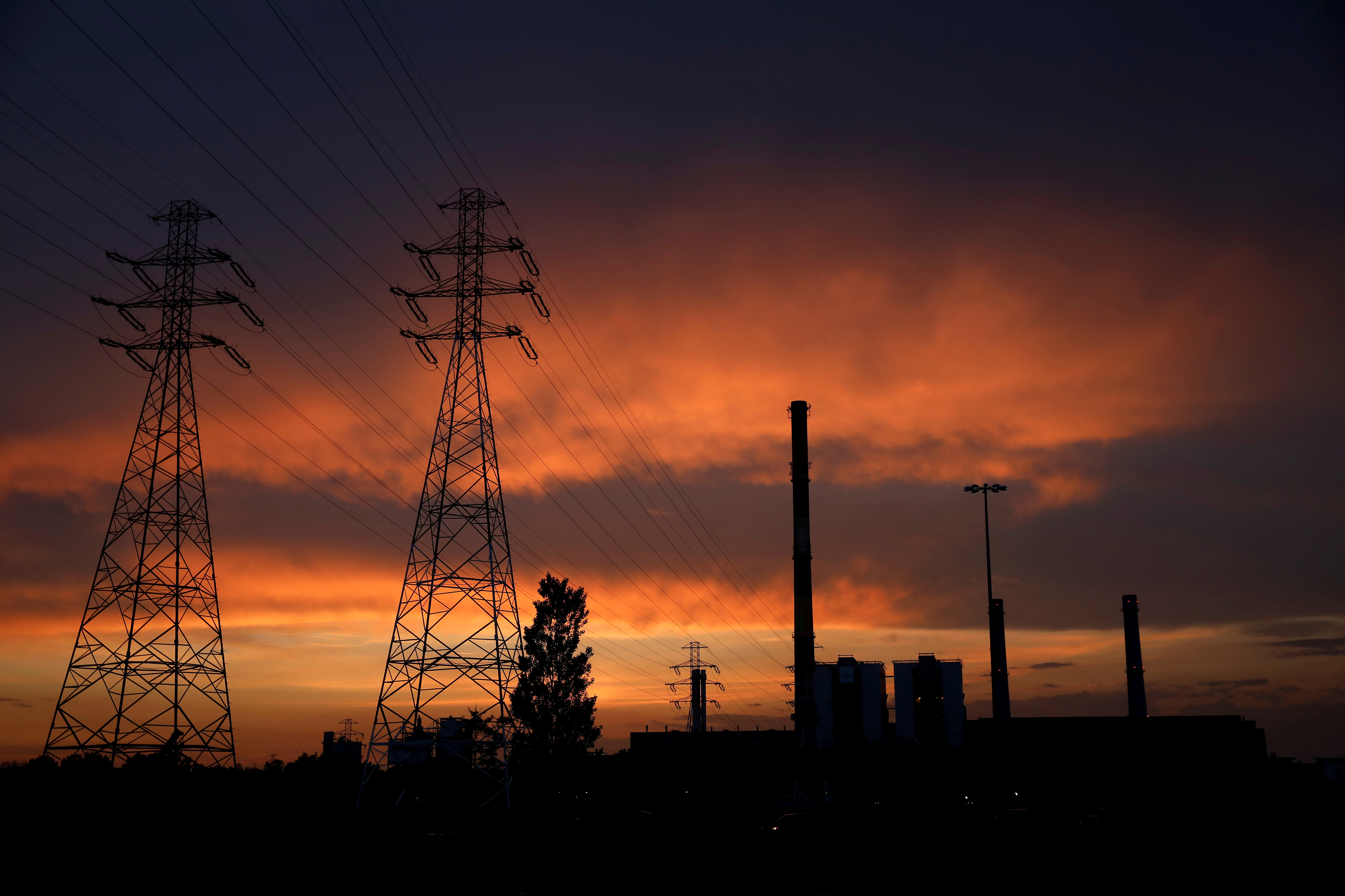 Electric poles are pictured in front of the PGNiG Termika Zeran thermal power station after sunset in Warsaw
