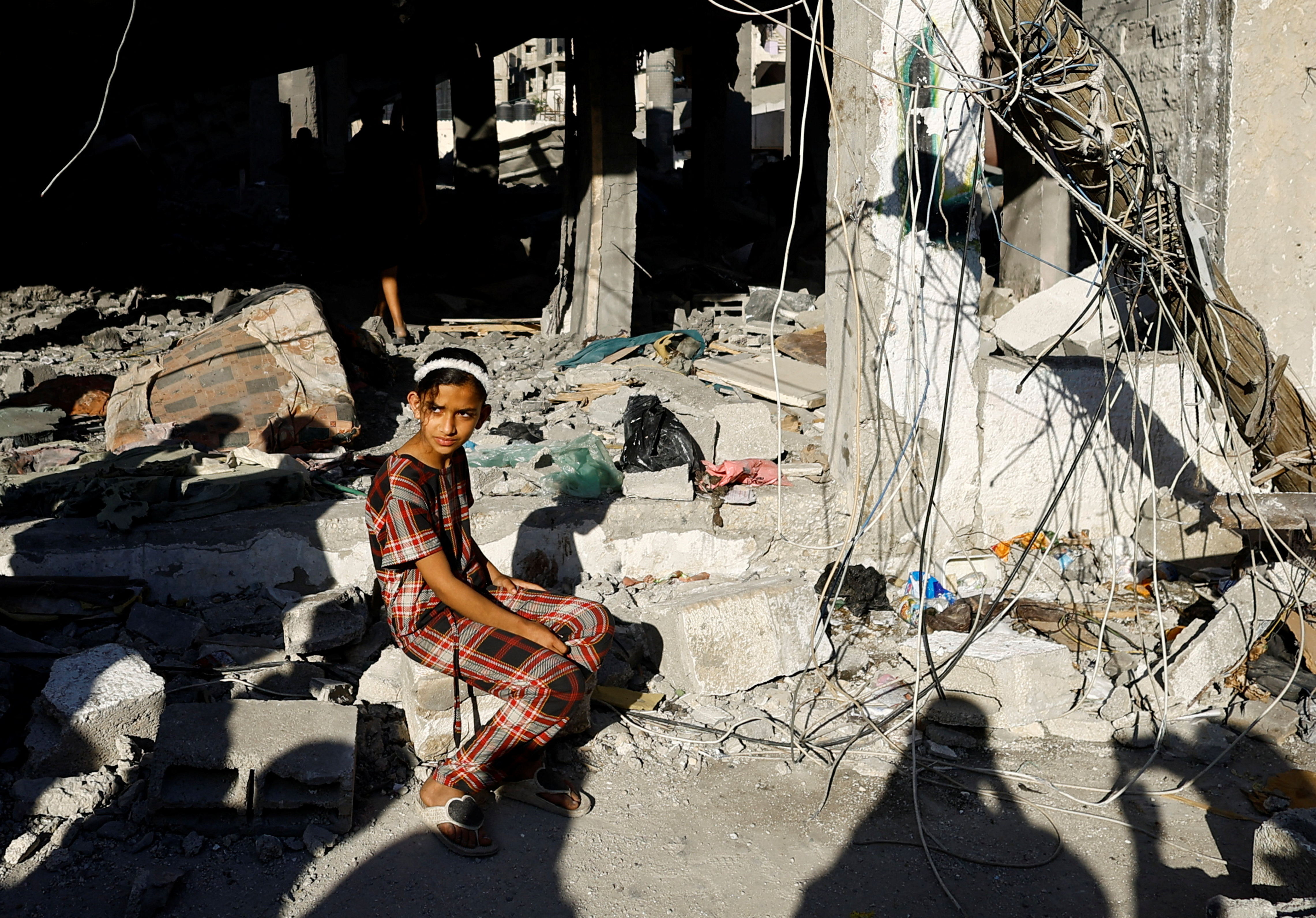 Palestinians react at the site of an Israeli strike on a house, in Rafah