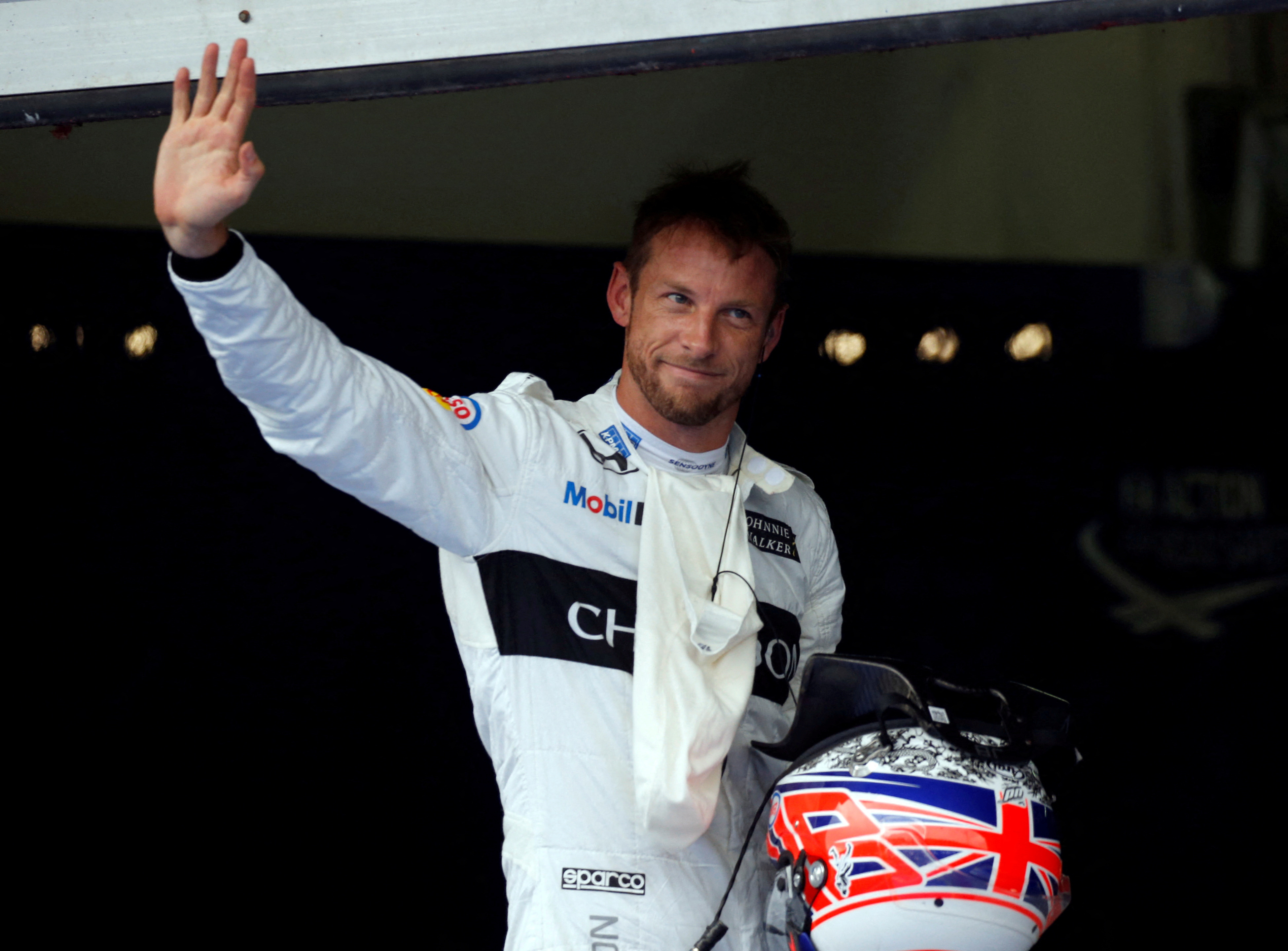 McLaren's Jenson Button of Britain waves after a qualifying session at the Formula One Malaysia Grand Prix in Sepang, Malaysia