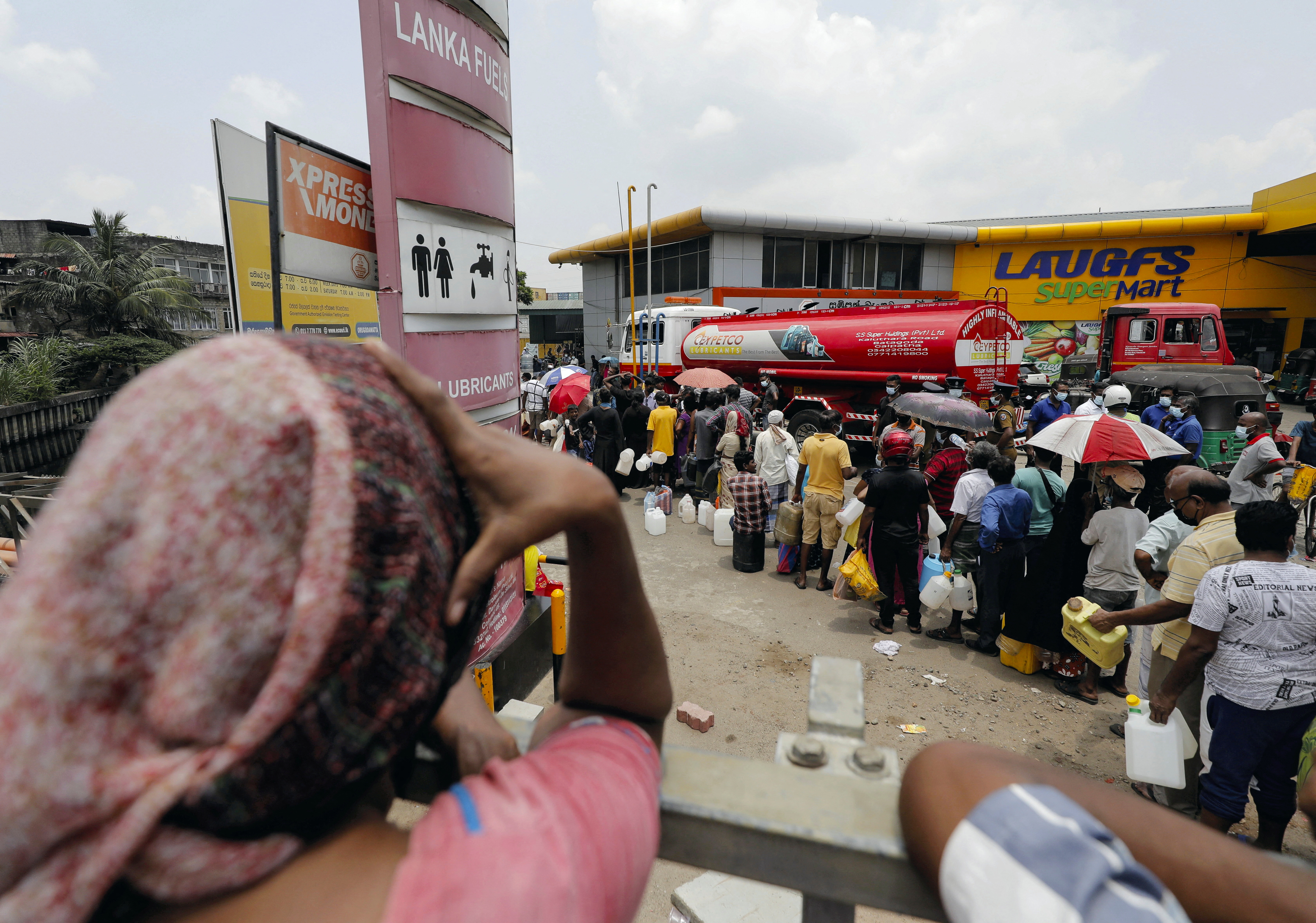 People queue to buy kerosene at a fuel station in Colombo