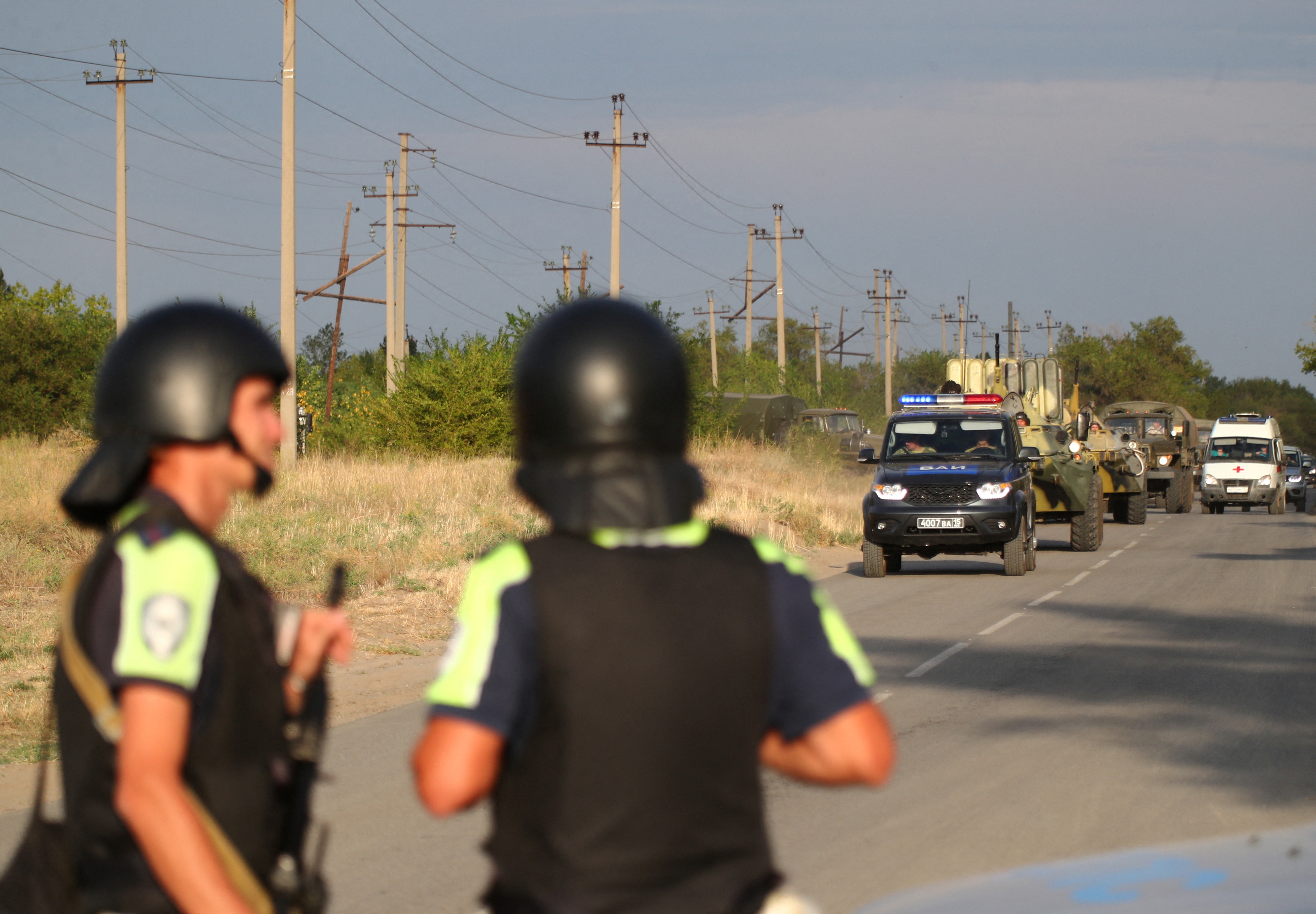 Law enforcement officers drive along a road following the seizure of hostages by a group of inmates in a penal colony in Surovikino