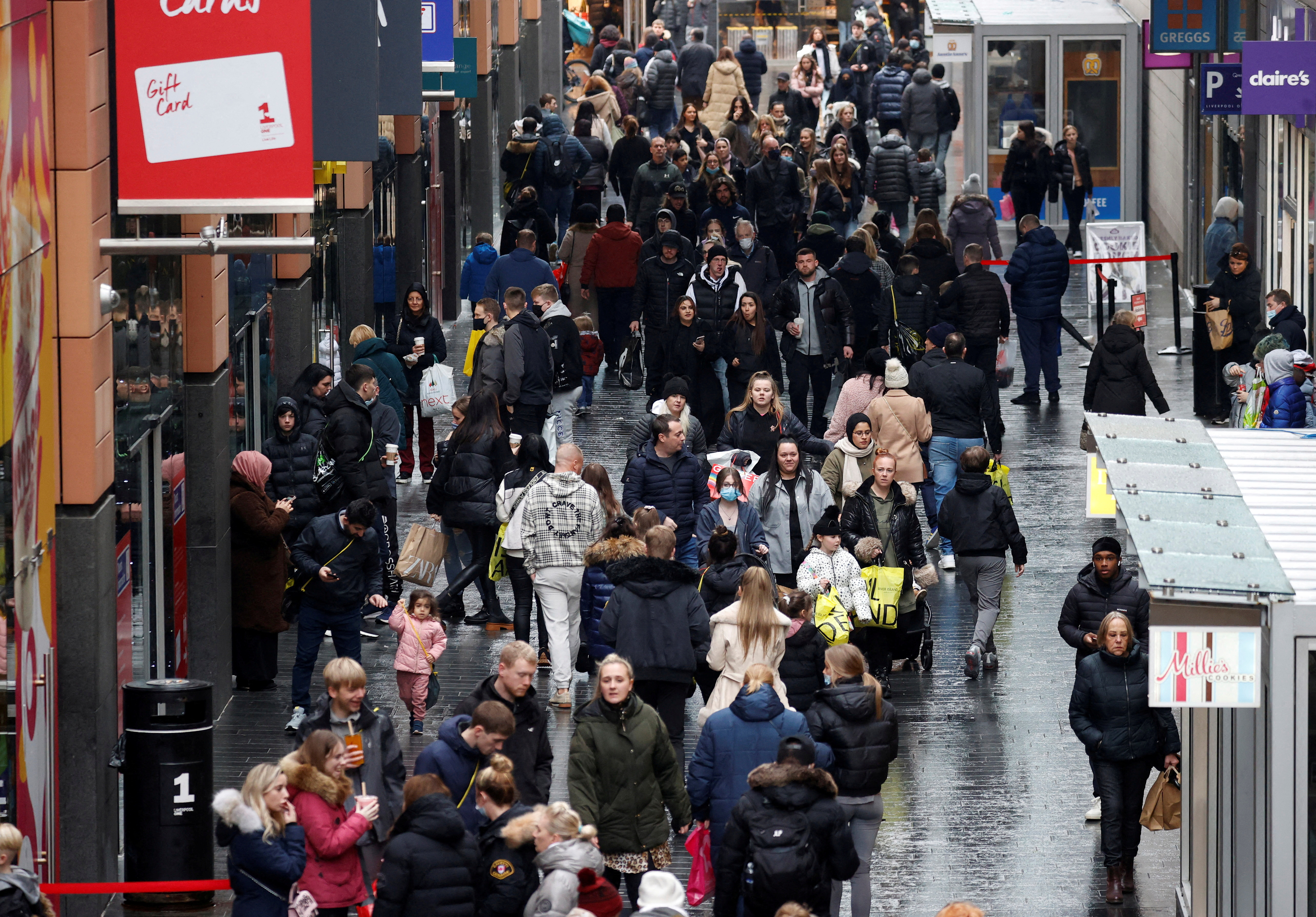 People walk along a busy shopping street as people look for bargains in the traditional Boxing Day sales in Liverpool