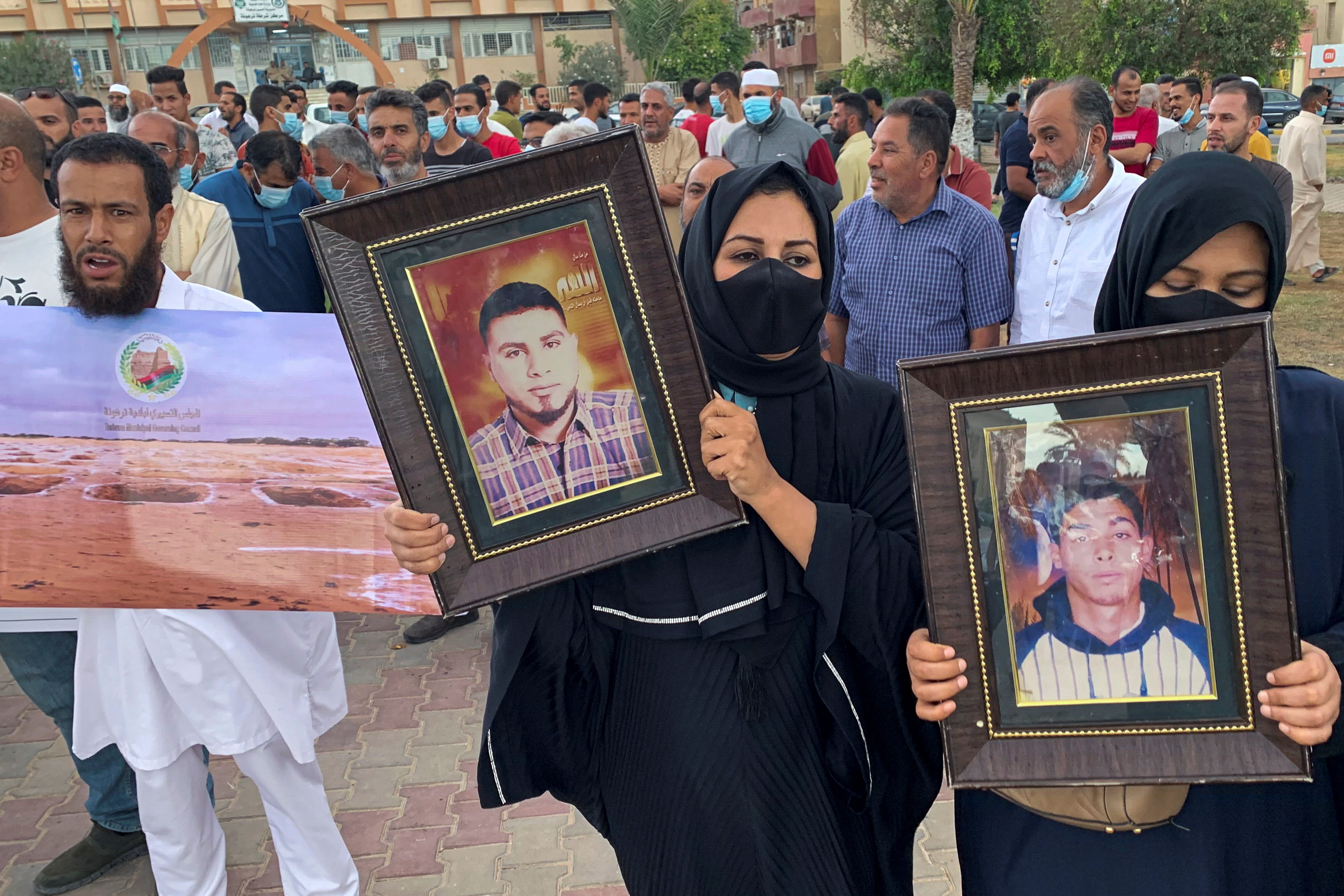 Families hold pictures of victims as they demand justice for missing loved ones and mass graves in Tarhouna, Libya, Oct. 9, 2021.  REUTERS/Ayman Al-Sahili