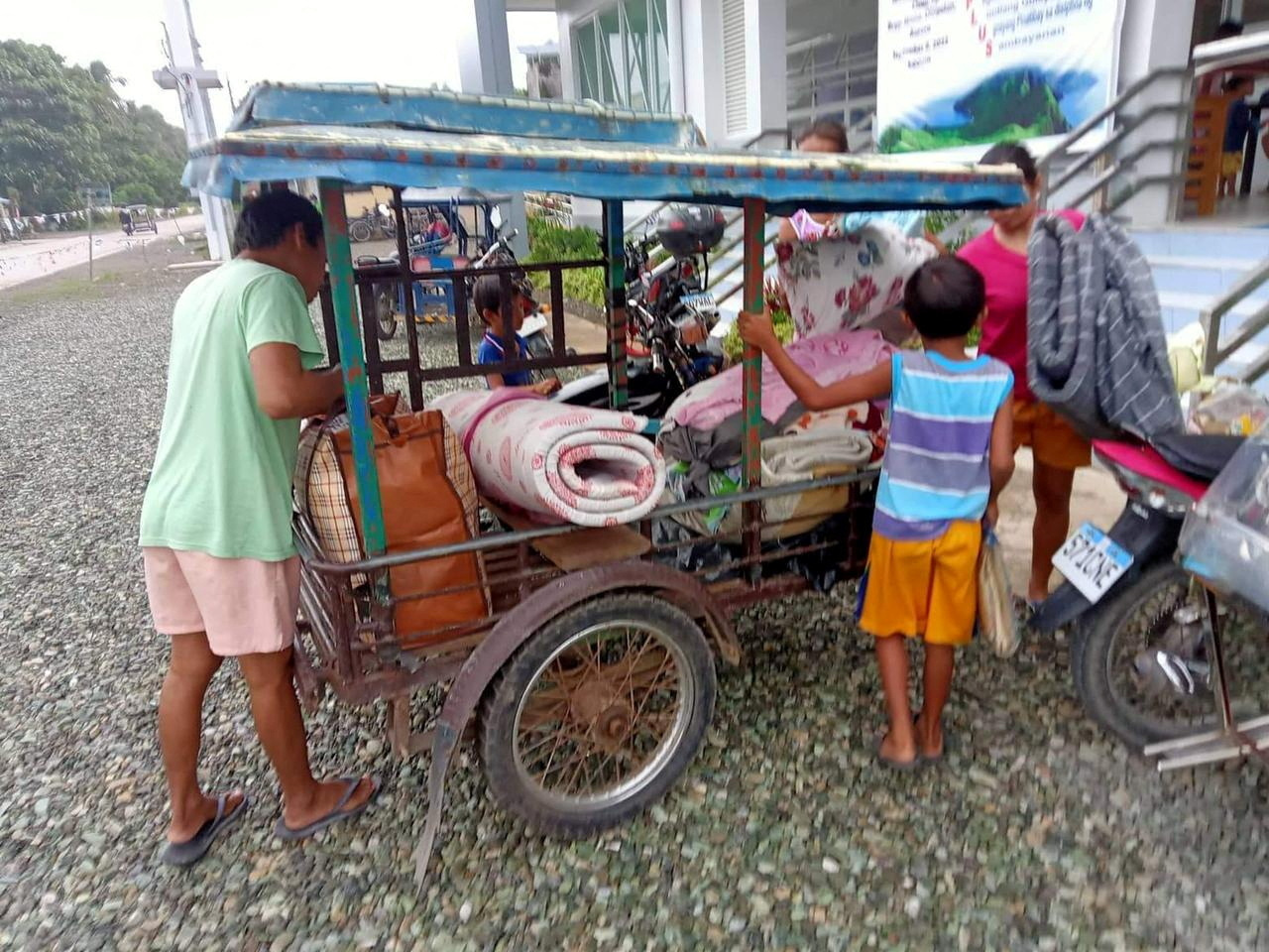 Residents carry belongings to evacuation centre in Aurora Province, Philippines