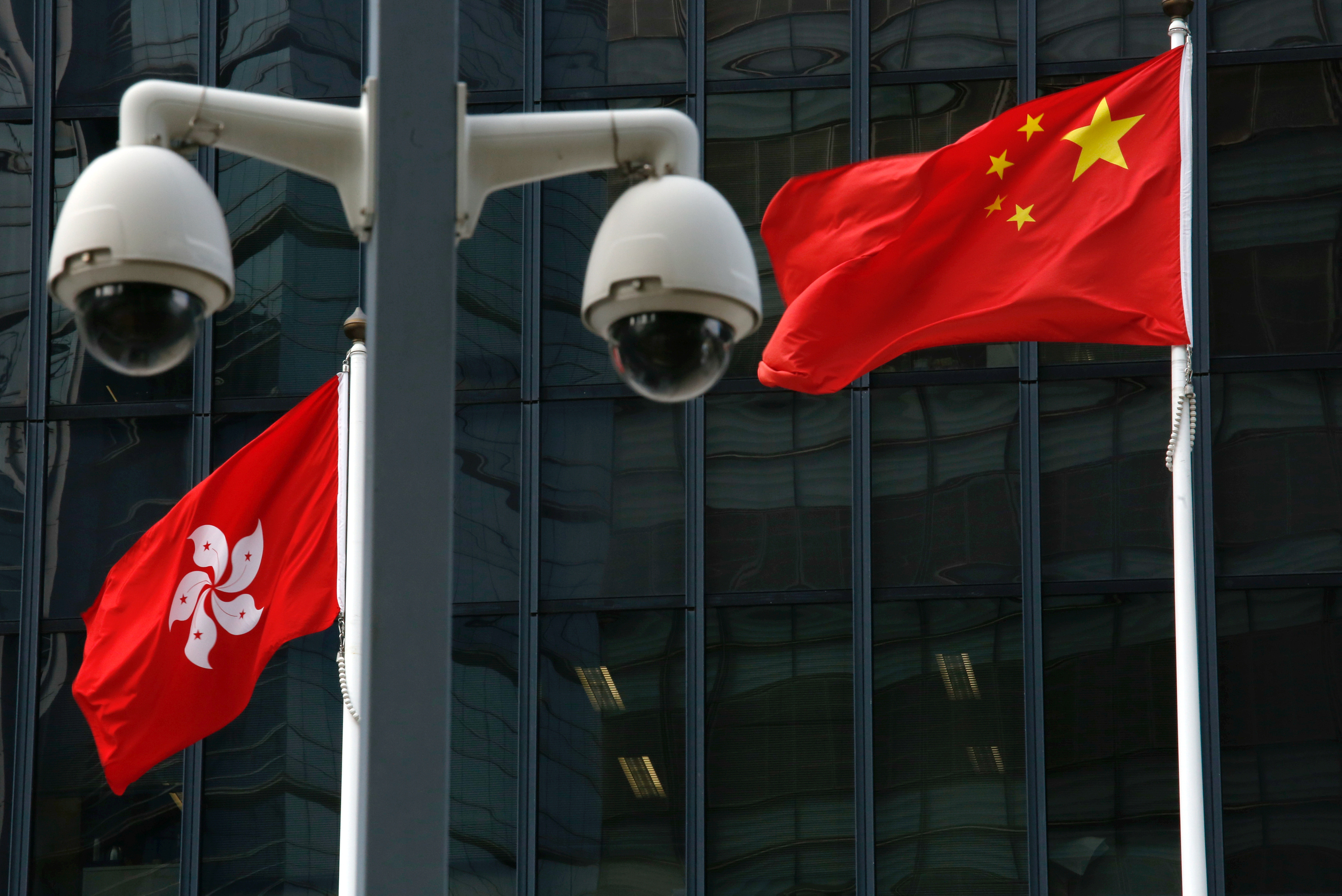 Chinese national flag and Hong Kong flag fly outside government headquarters in Hong Kong