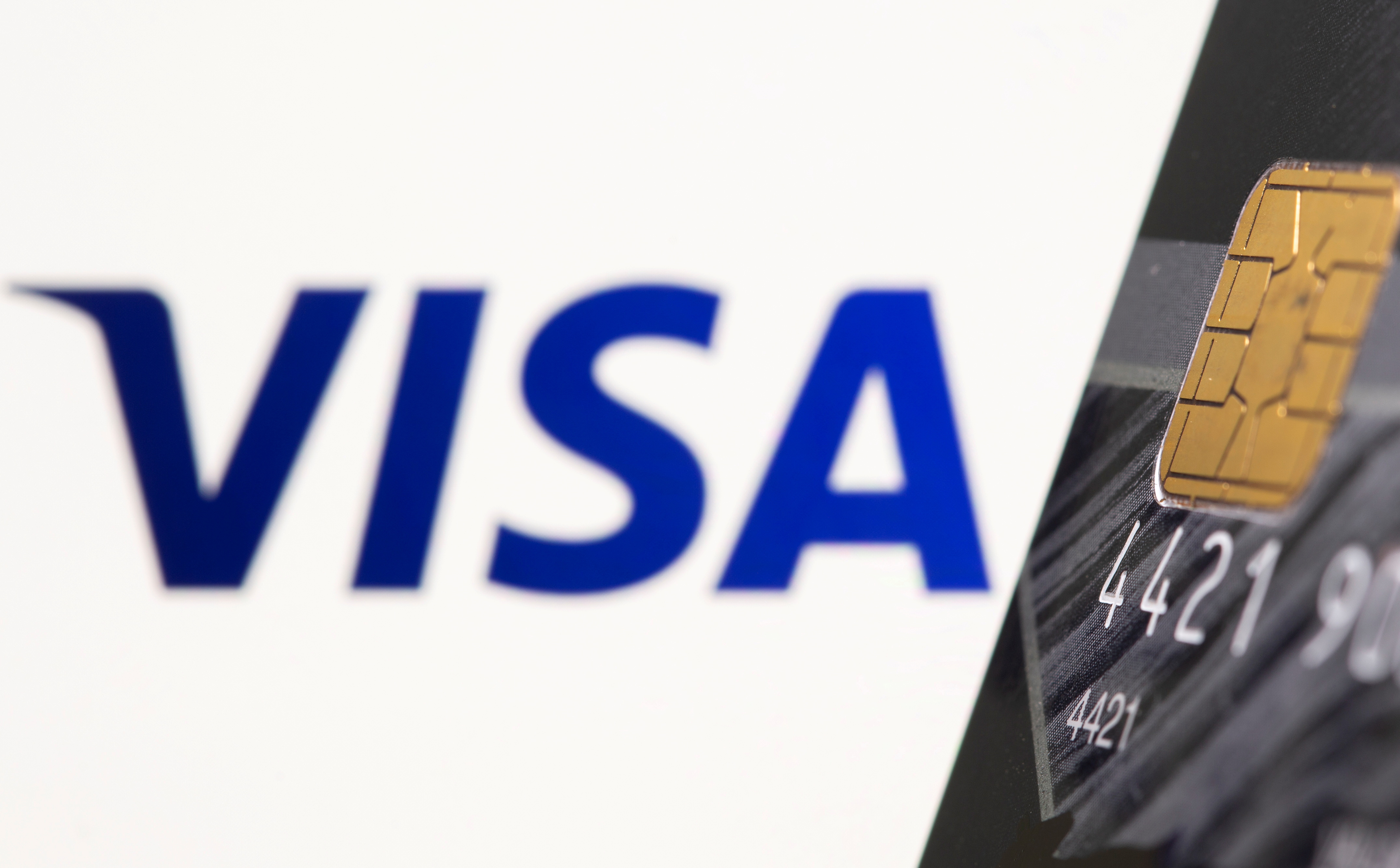 Credit card is seen in front of displayed Visa logo in this illustration taken, July 15, 2021. REUTERS/Dado Ruvic/Illustration/File Photo