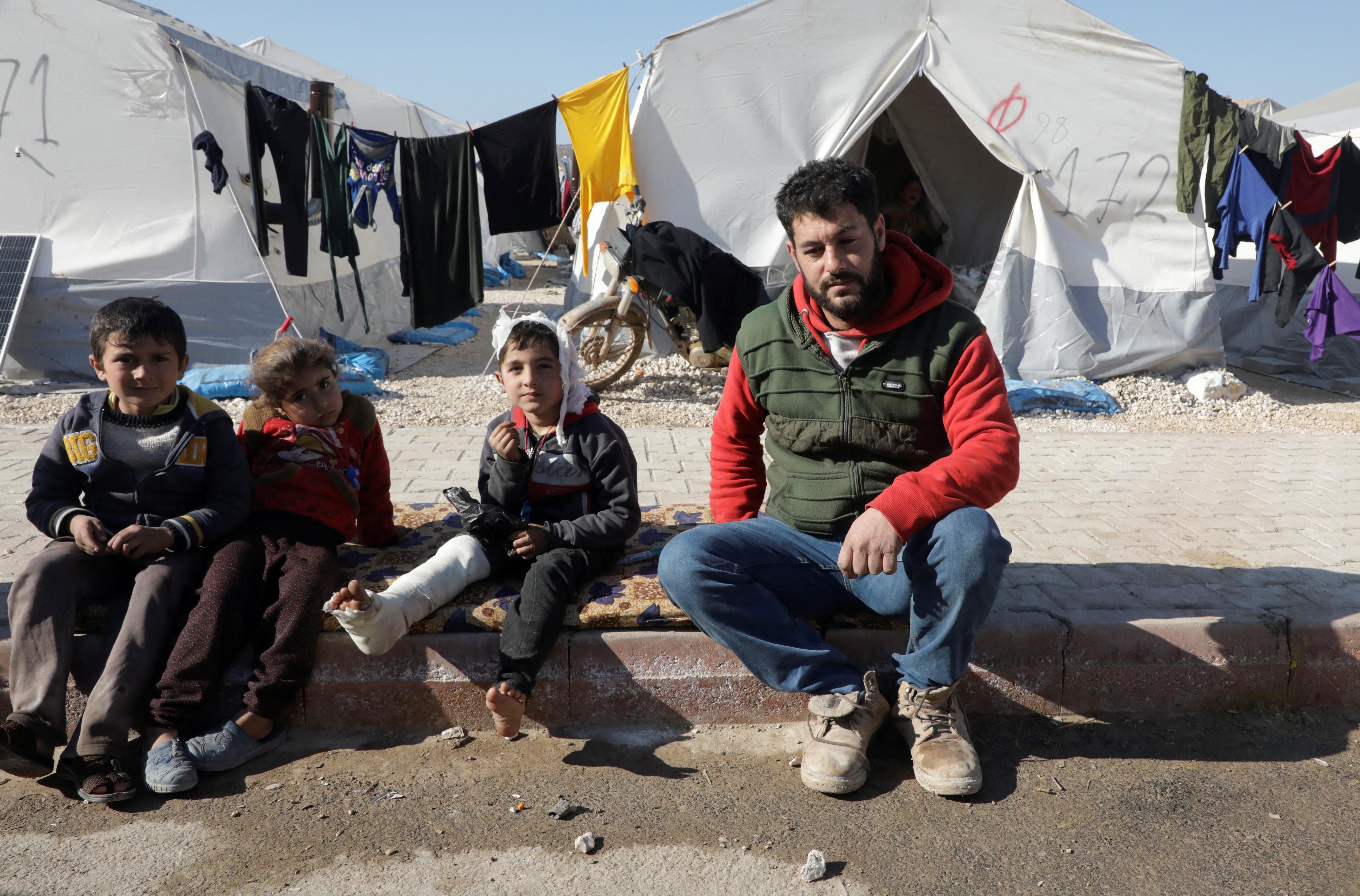 Displaced Syrian man, Omar Barakat, sits at a camp for earthquake survivors, on the outskirts of rebel-held town of Jandaris