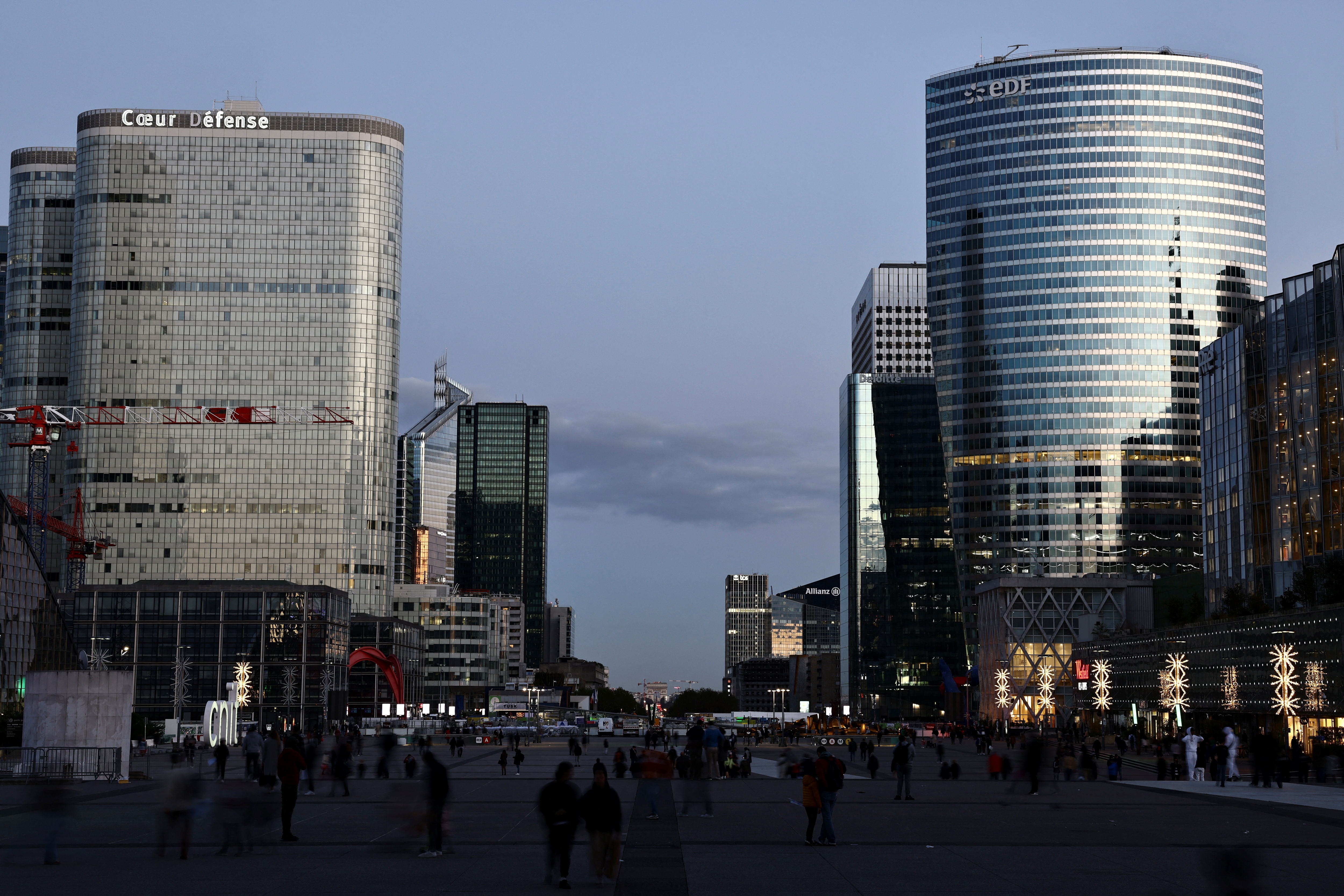 People walk through the financial and business district of La Defense near Paris