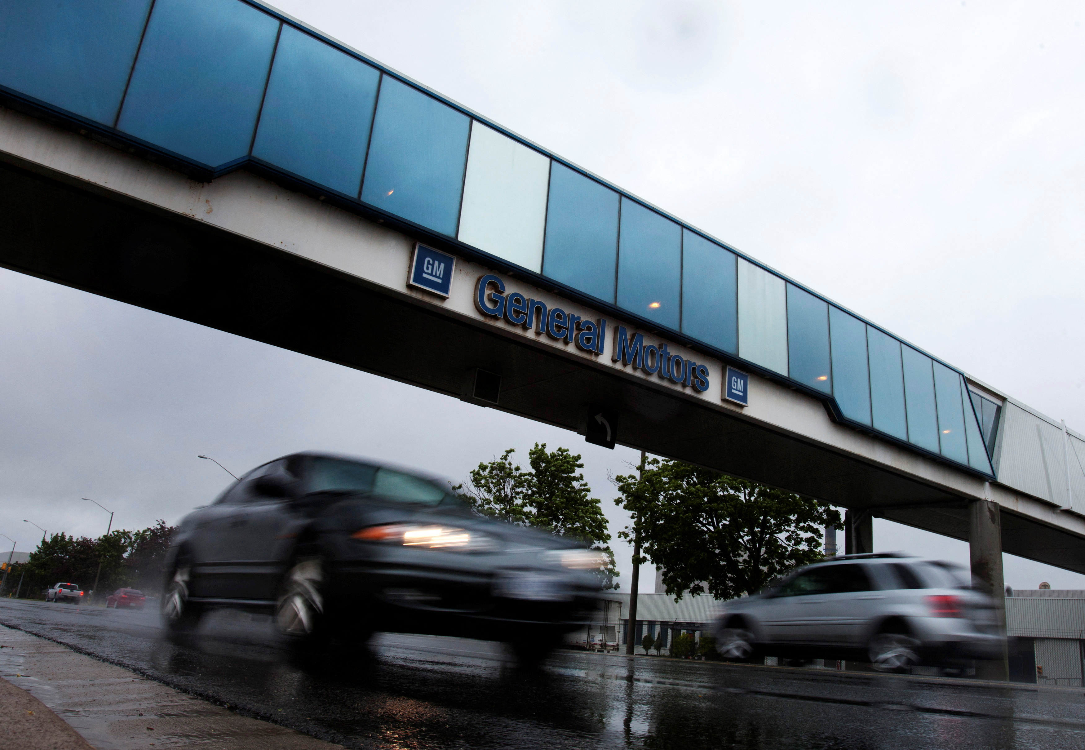 Cars pass under an overpass at the General Motors Car assembly plant in Oshawa