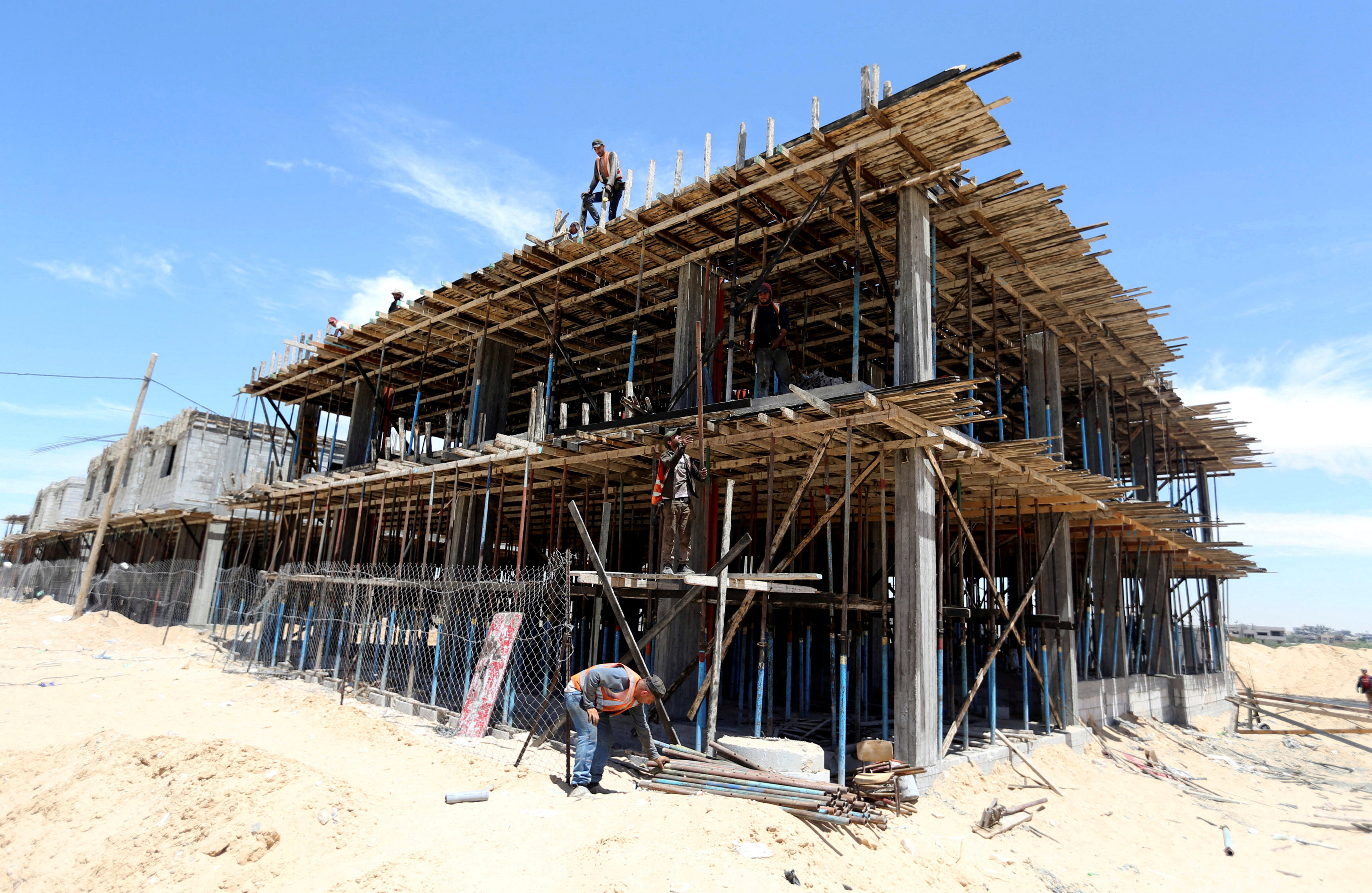 Palestinian workers work in a Qatari-funded construction project in the southern Gaza Strip