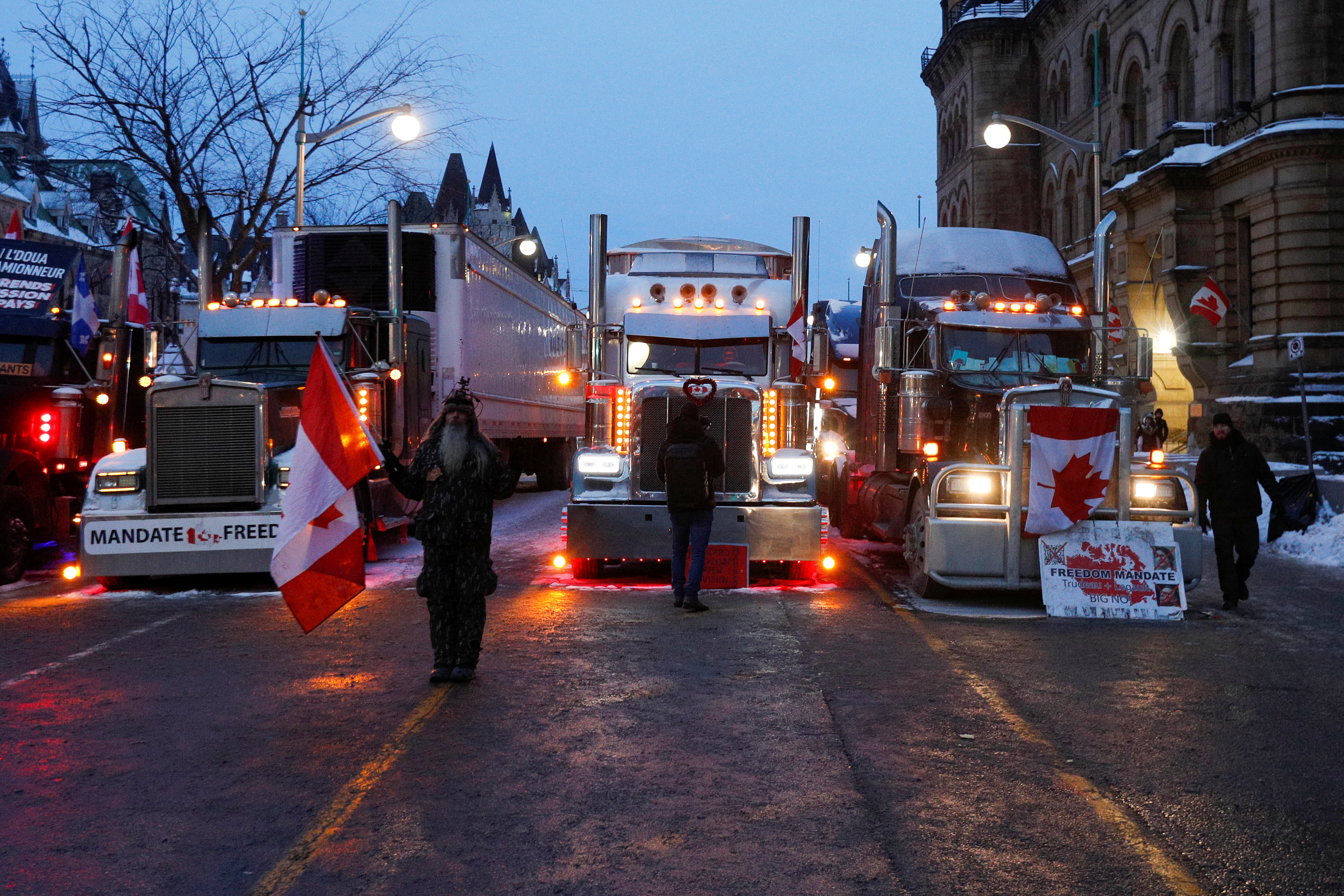 A protester stands near trucks across from Parliament Hill as truckers and supporters continue to protest coronavirus disease (COVID-19) vaccine mandates, in Ottawa, Ontario, Canada, February 4, 2022. REUTERS/Lars Hagberg