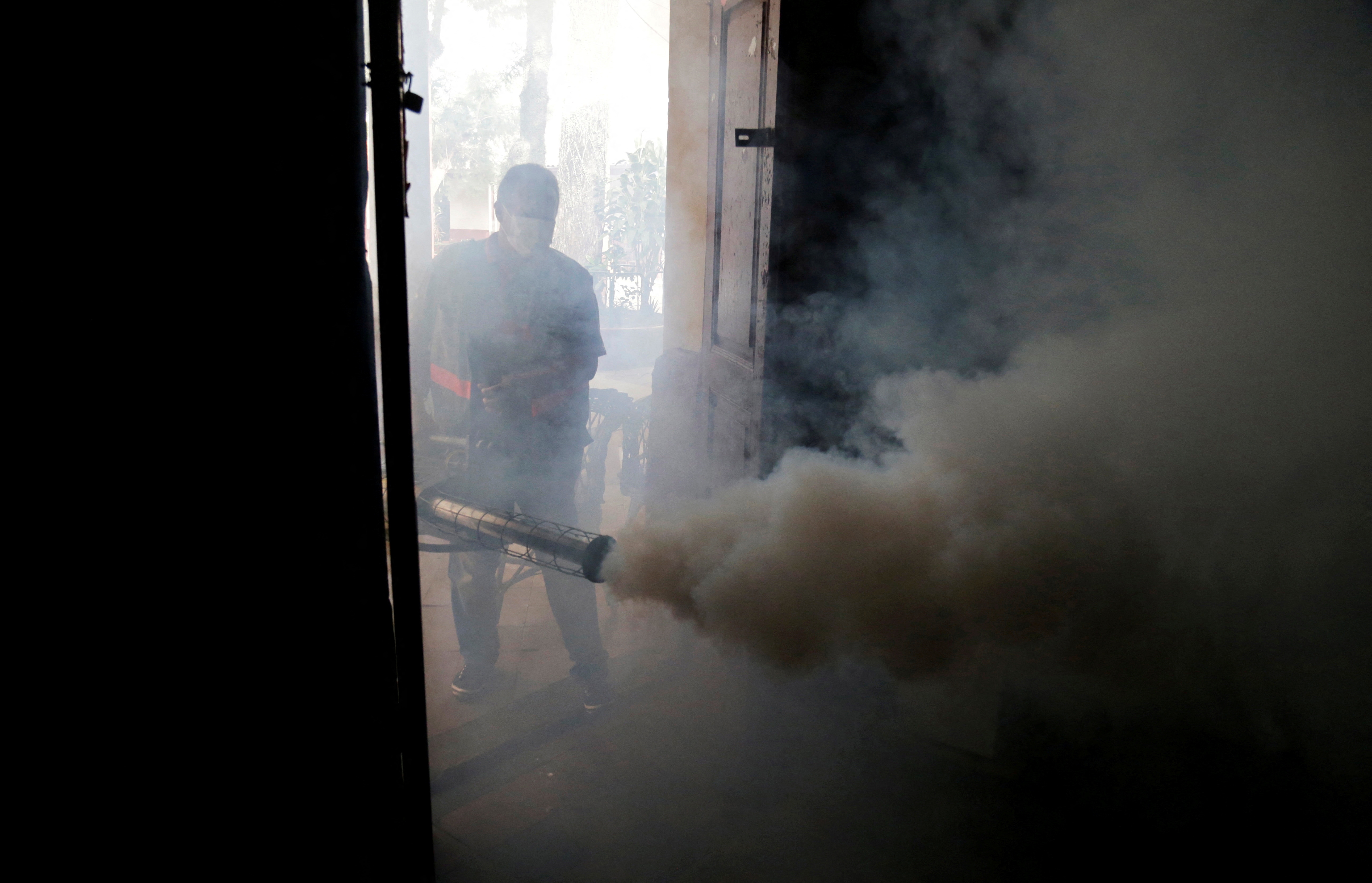 A federal health worker takes part in fumigation to prevent the proliferation of mosquitos that transmit the Dengue fever at the San Lorenzo National School, in a low-income neighbourhood of San Lorenzo