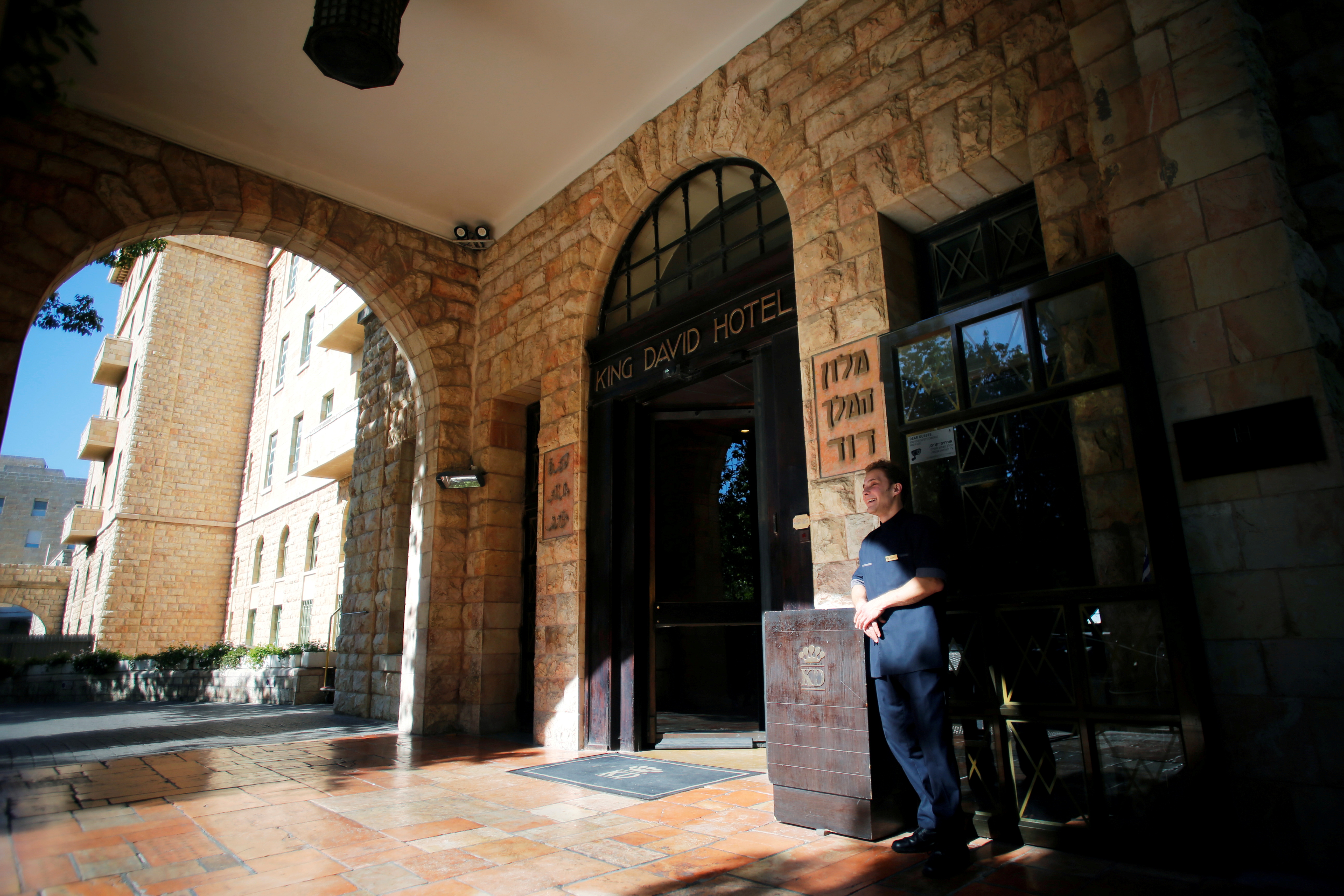 A hotel employee stands at the entrance to the King David Hotel in Jerusalem