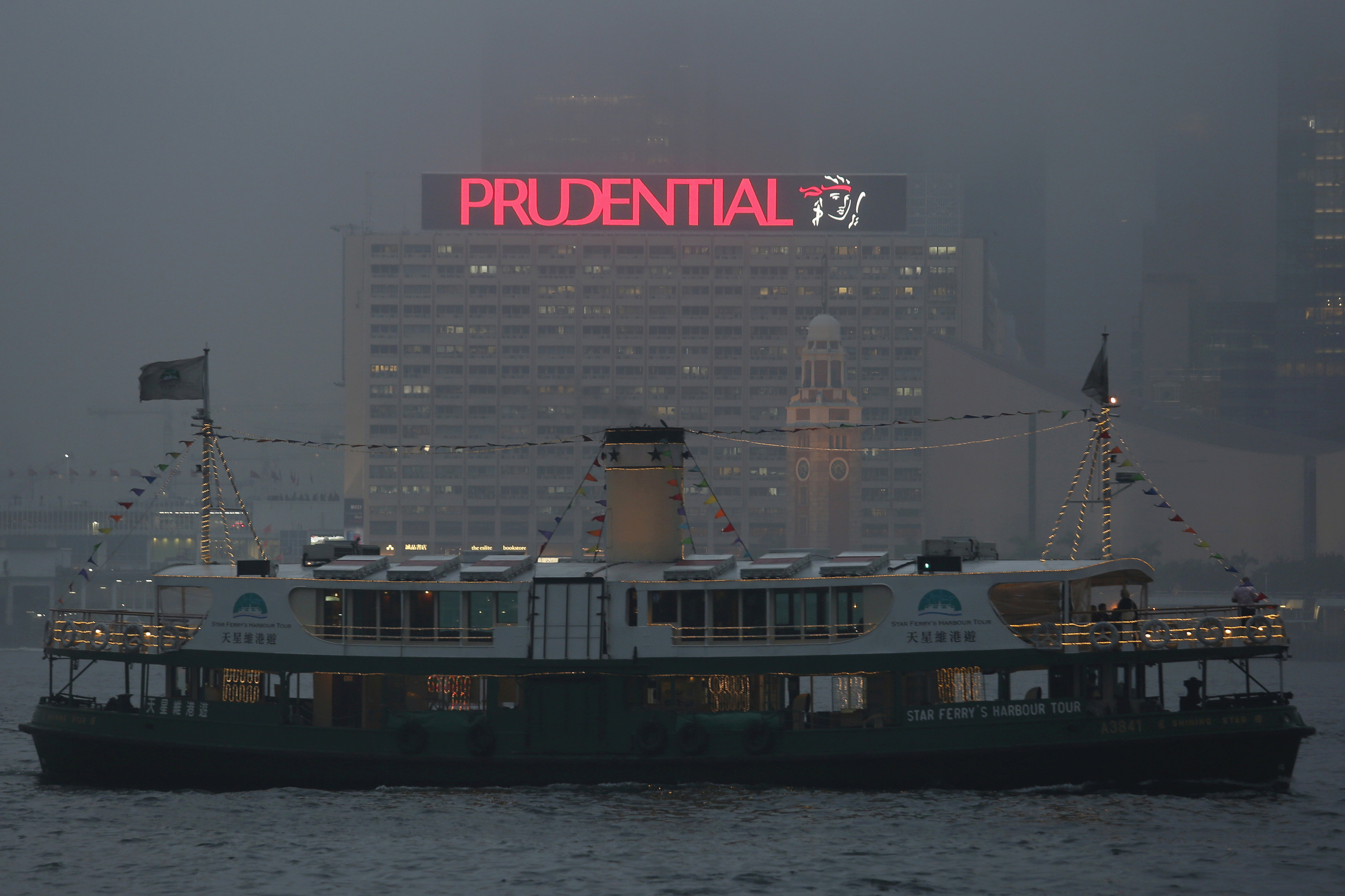 A ferry sails past an advertisement of Prudential Assurance under foggy weather at the Victoria Harbour in Hong Kong