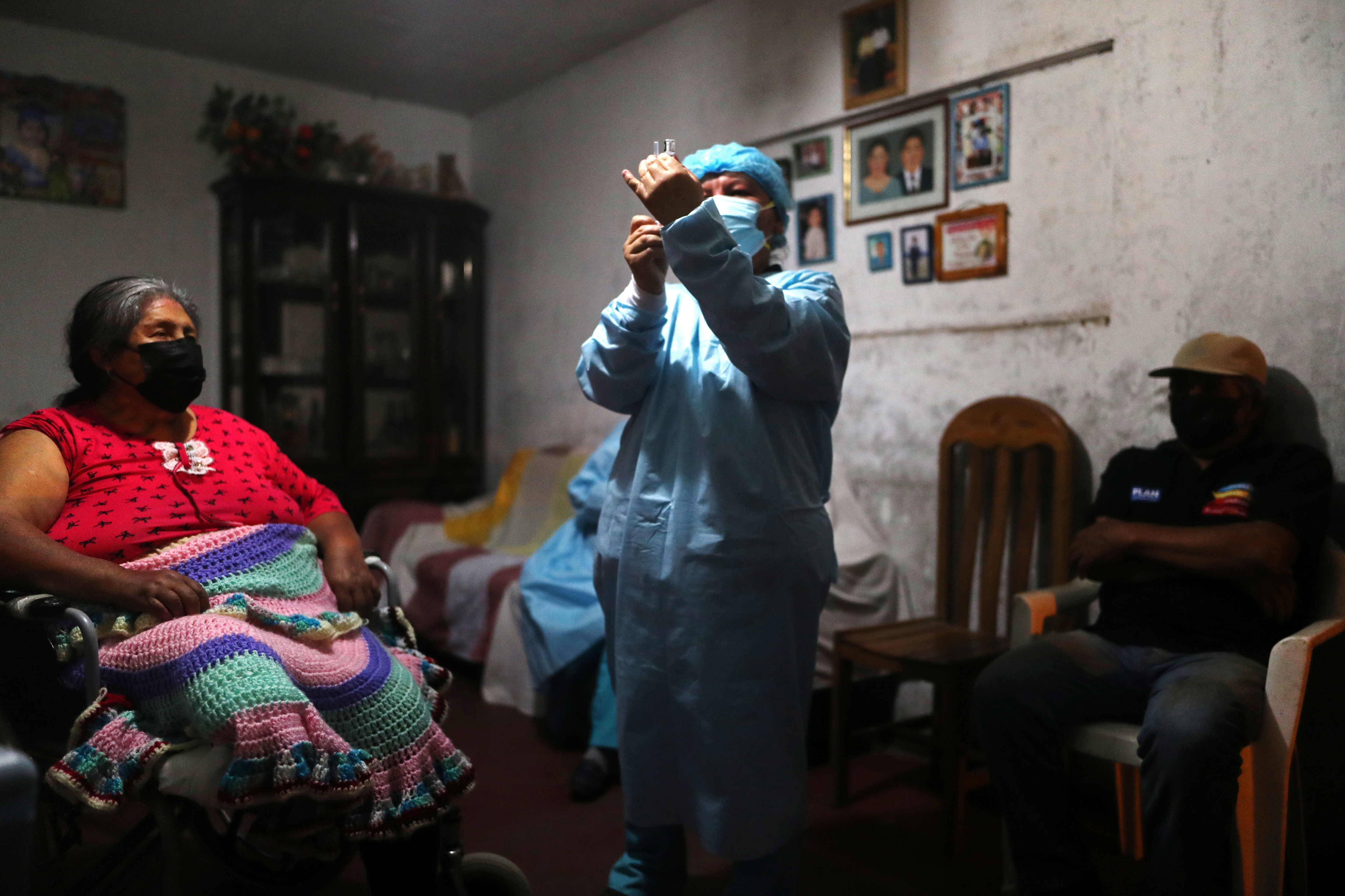 A healthcare worker administers a dose of the Pfizer-BioNTech coronavirus disease (COVID-19) vaccine to a woman during an initiative to vaccinate people over 12 years old, in Lima, Peru December 6, 2021. REUTERS/Sebastian Castaneda 