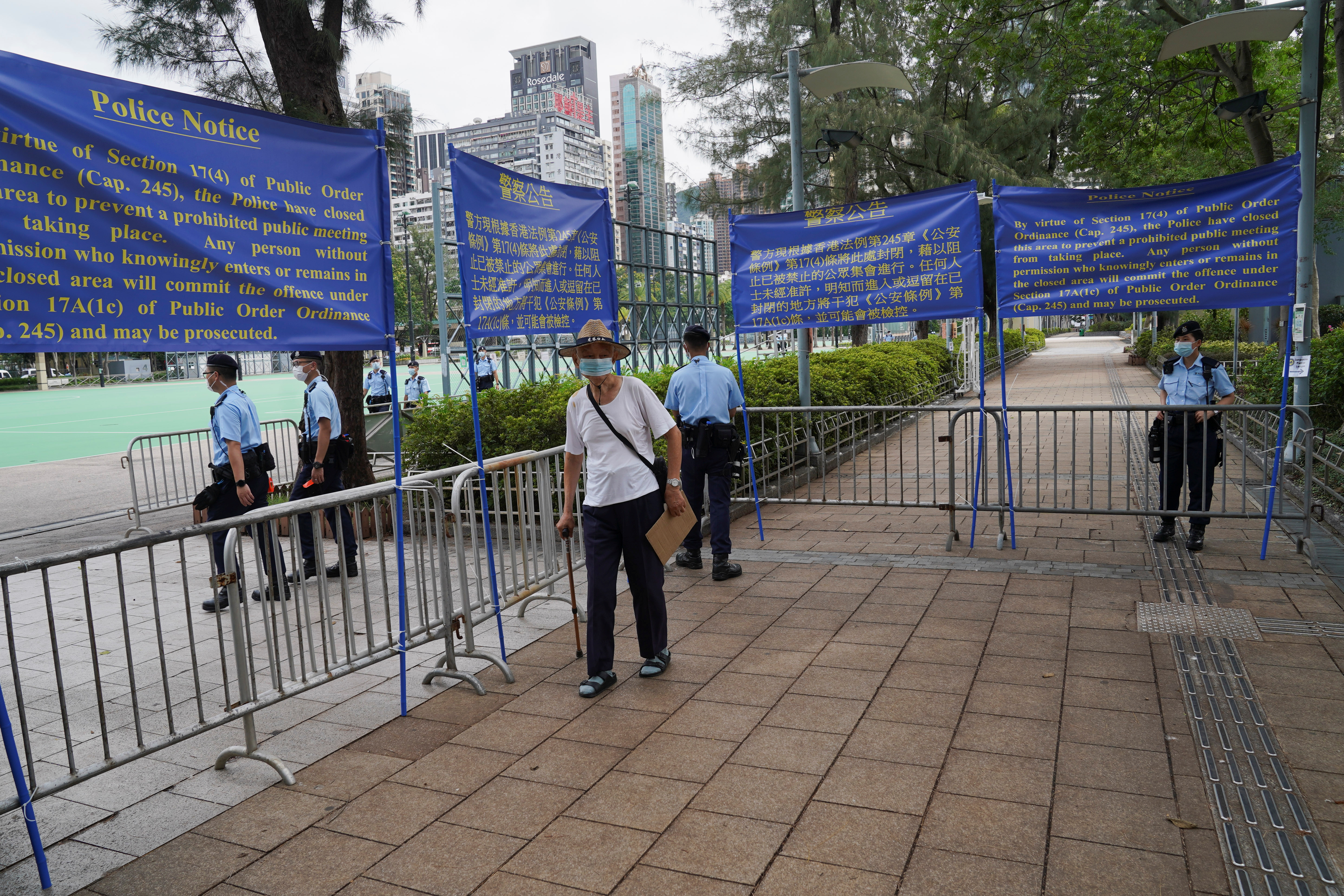 A man walks past police officers, as they stand guard after blocking Victoria Park on the 32nd anniversary of the crackdown on pro-democracy demonstrators at Beijing's Tiananmen Square in 1989, in Hong Kong, China June 4, 2021. REUTERS/Lam Yik