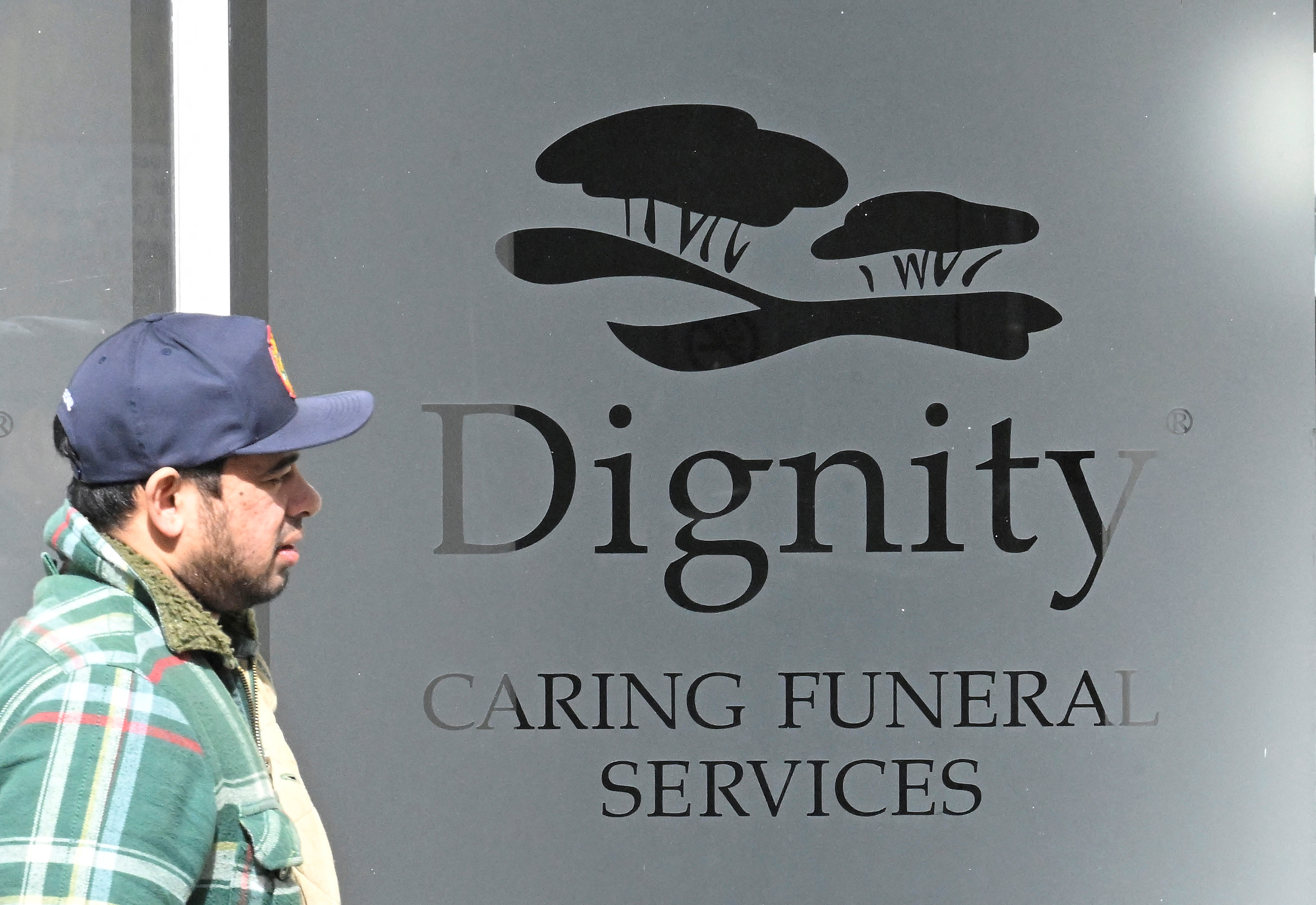 A man walks past a Dignity funeral directors building in London