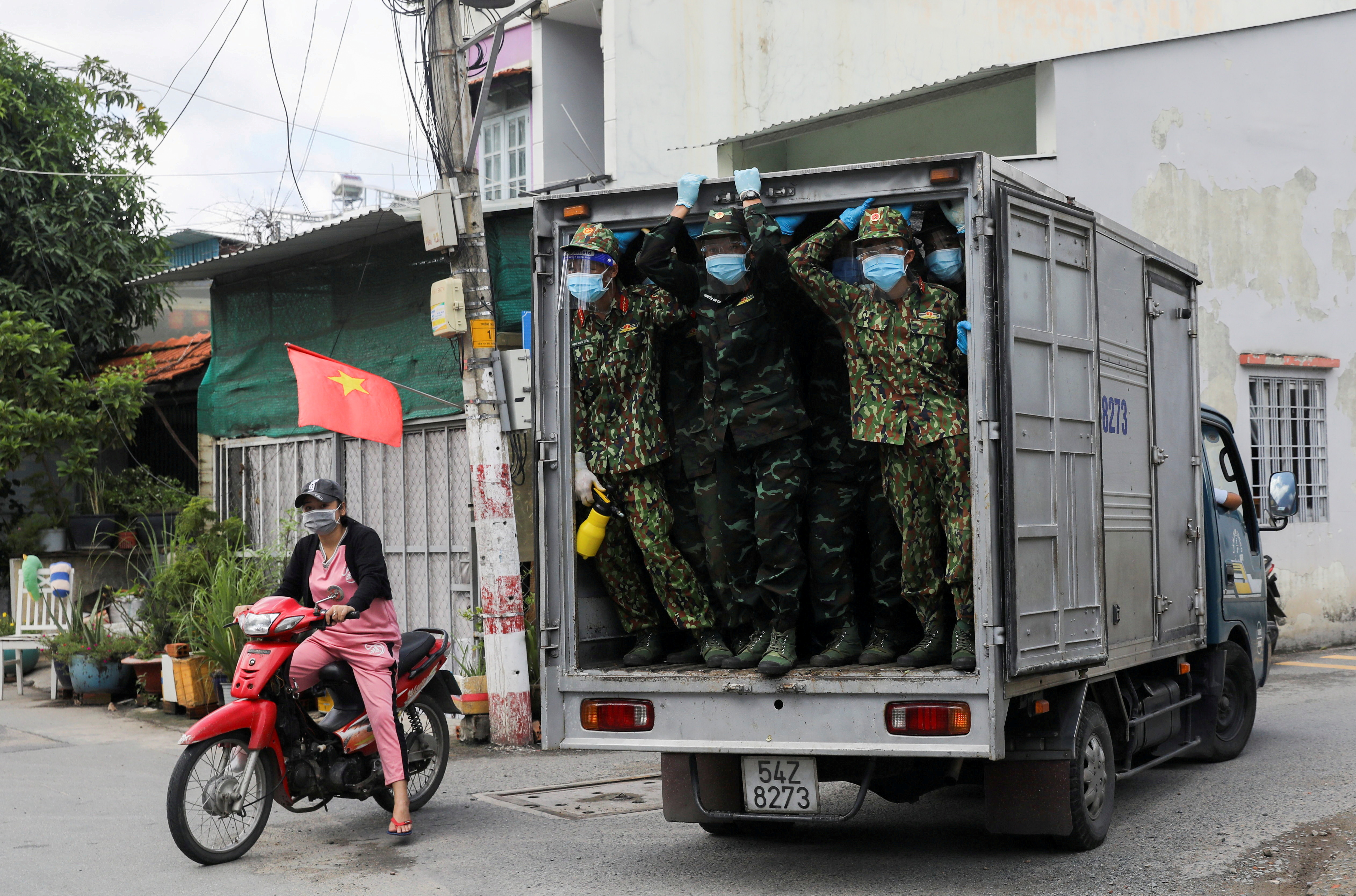 Vietnamese soldiers look out from a truck as they deliver food in strict lockdown areas amid the coronavirus disease (COVID-19) pandemic in Ho Chi Minh
