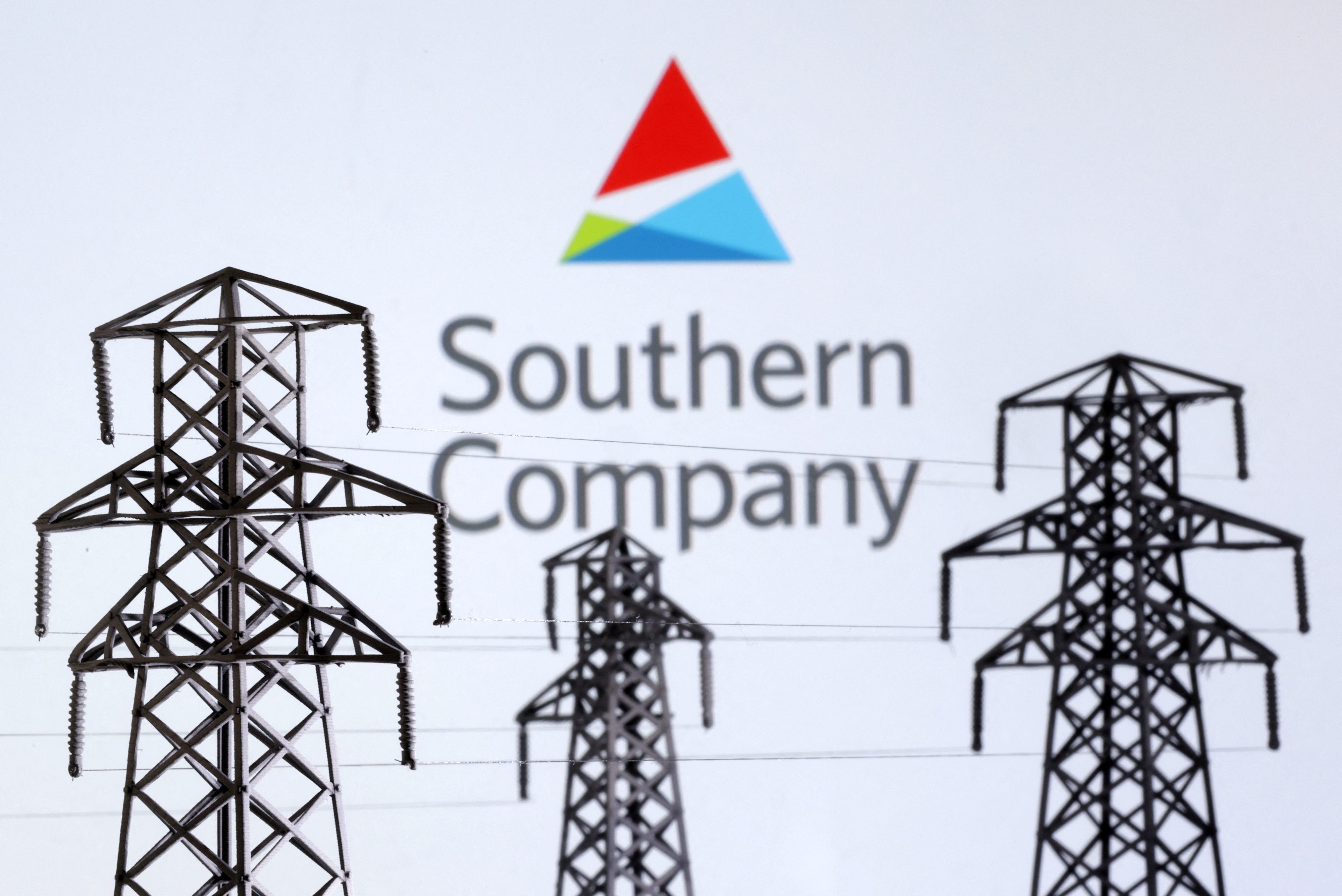 Illustration shows Electric power transmission pylon miniatures and Southern Company logo