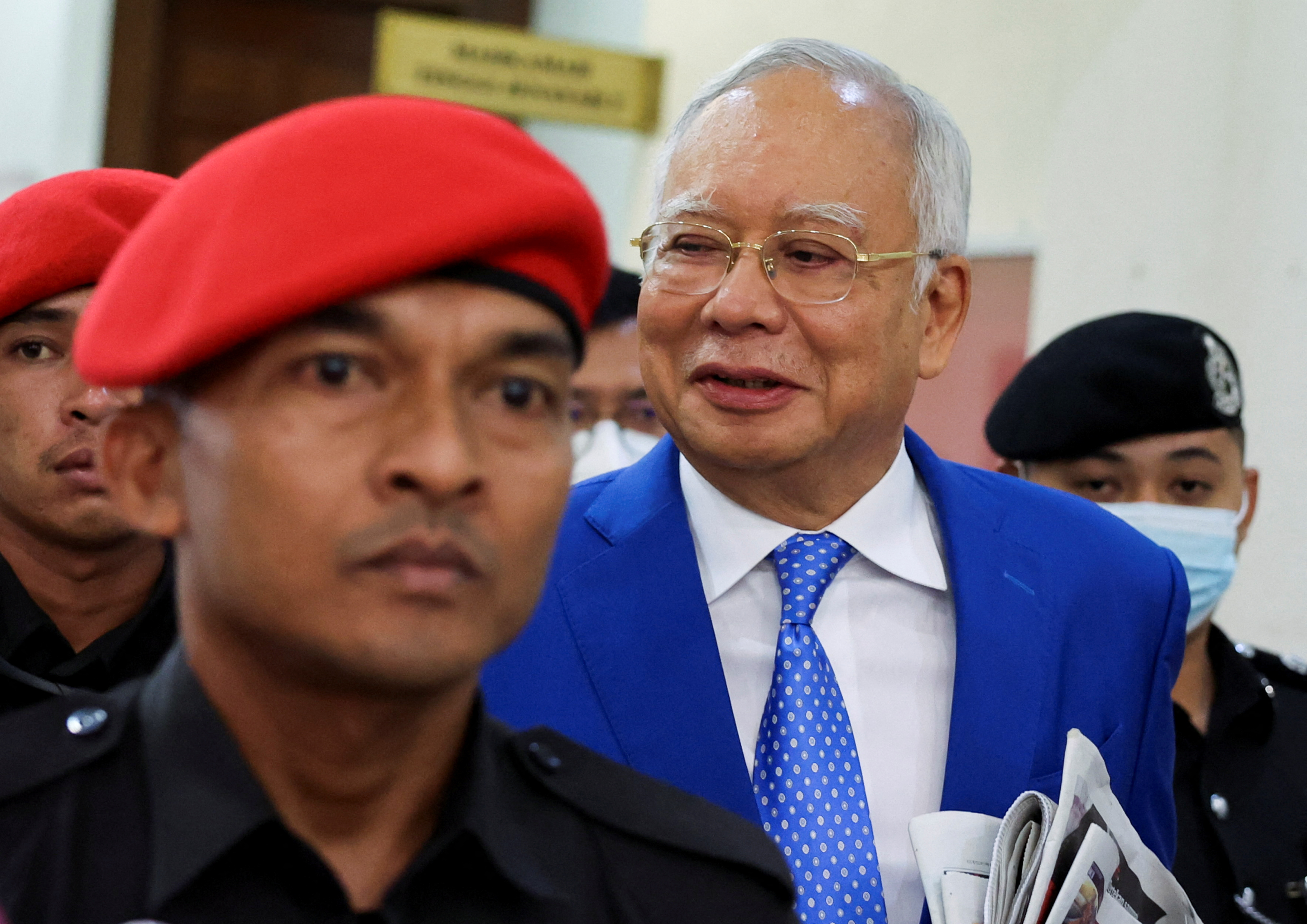 Former Malaysian Prime Minister Najib Razak is escorted by prison officers as the jailed politician leaves the court after court proceedings in Kuala Lumpur