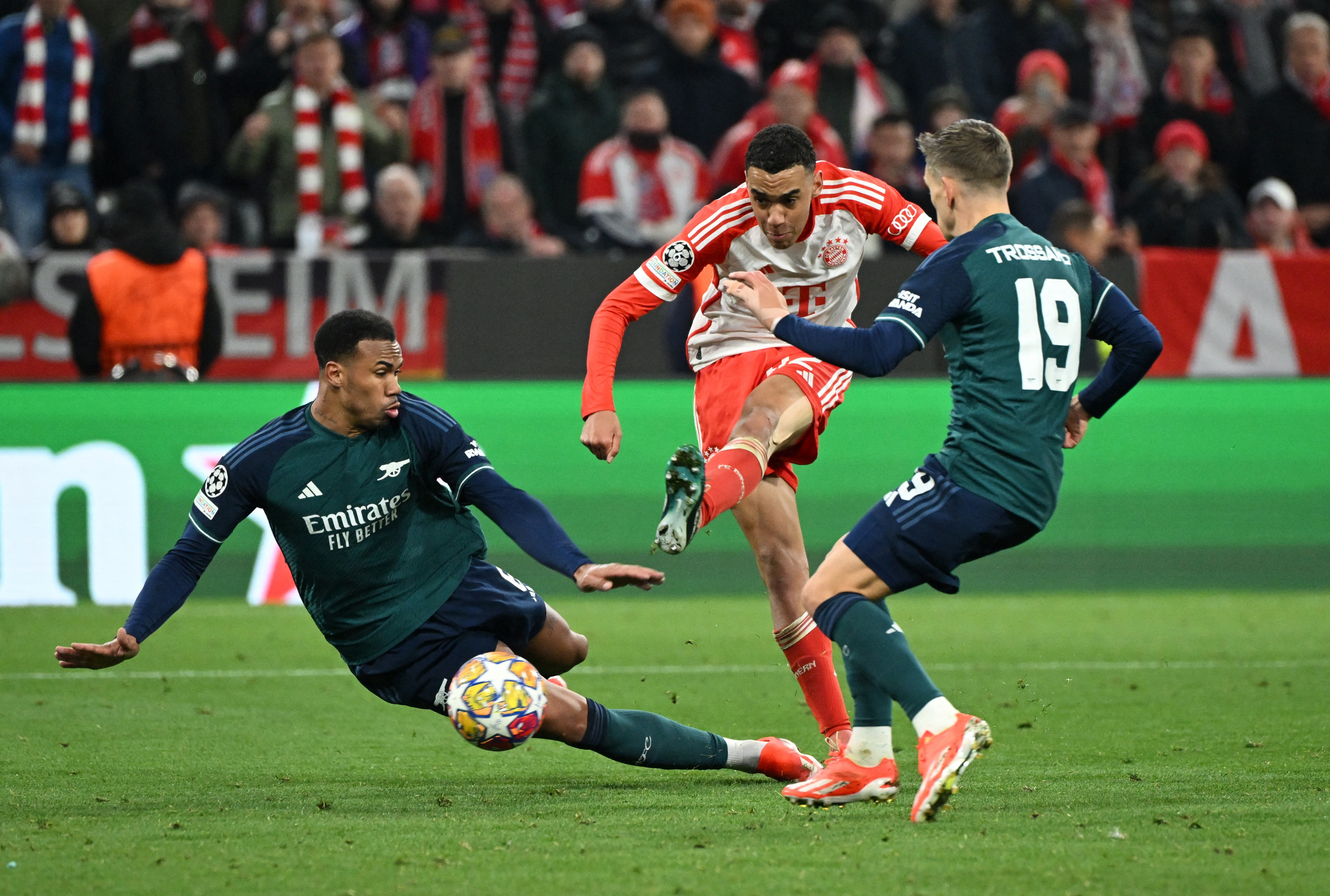 Soccer Football - Champions League - Quarter Final - Second Leg - Bayern Munich v Arsenal - Allianz Arena, Munich, Germany - April 17, 2024 Bayern Munich's Jamal Musiala in action with Arsenal's Gabriel and Leandro Trossard REUTERS/Angelika Warmuth