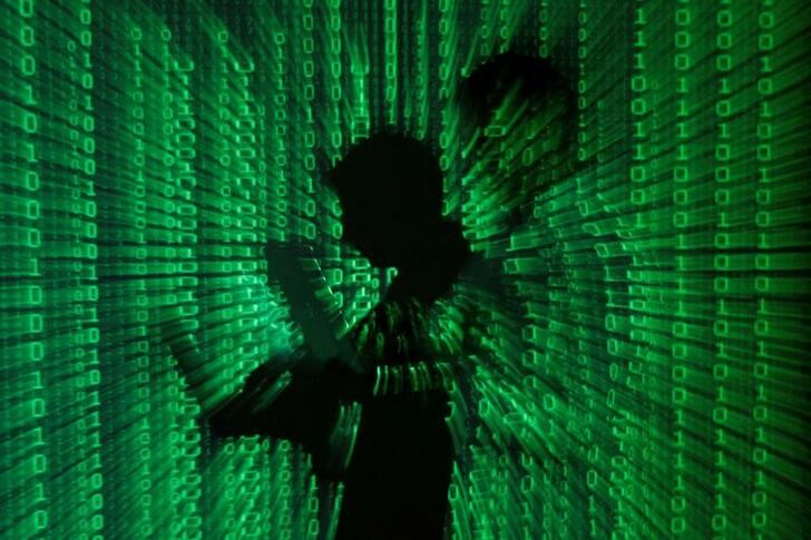 An illustration picture shows projection of binary code on man holding laptop computer