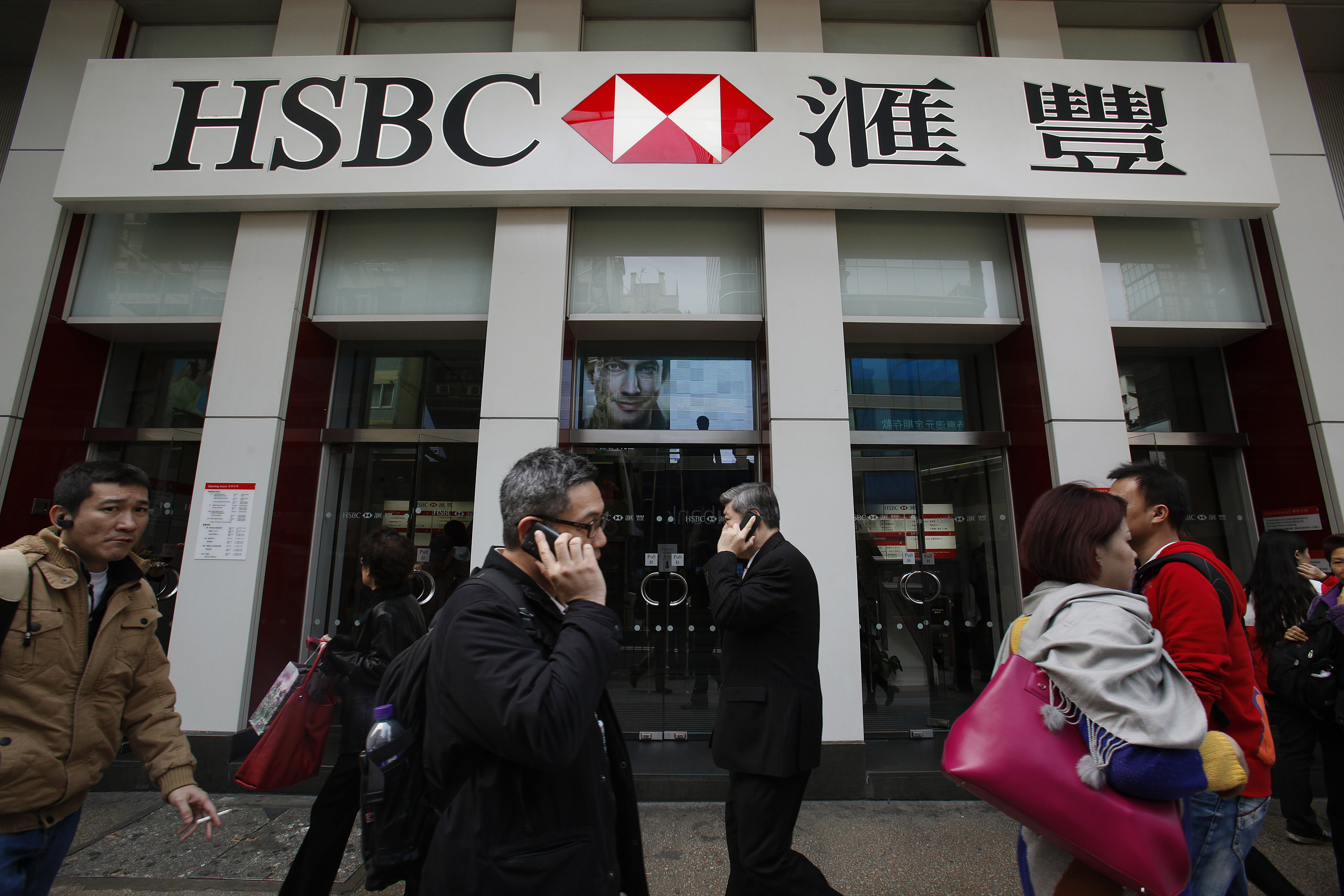 People walk outside one of the branches of HSBC in Hong Kong