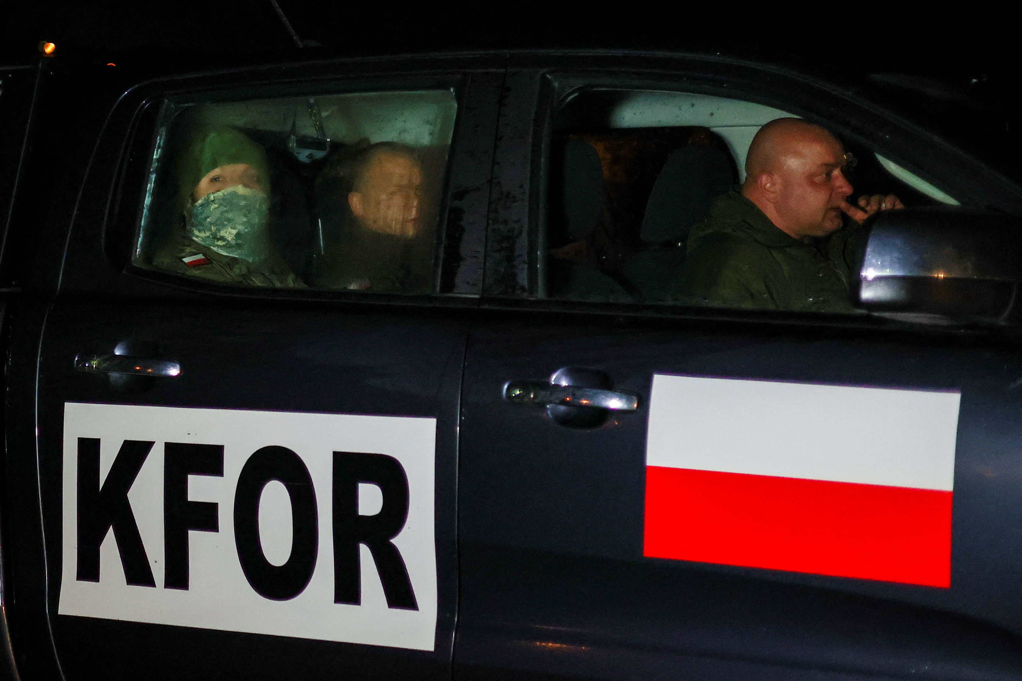 Members of the Polish Armed Forces, part of NATO peacekeepers mission in Kosovo, stay in a vehicle near the barricade in the northern part of the ethnically-divided town of Mitrovica