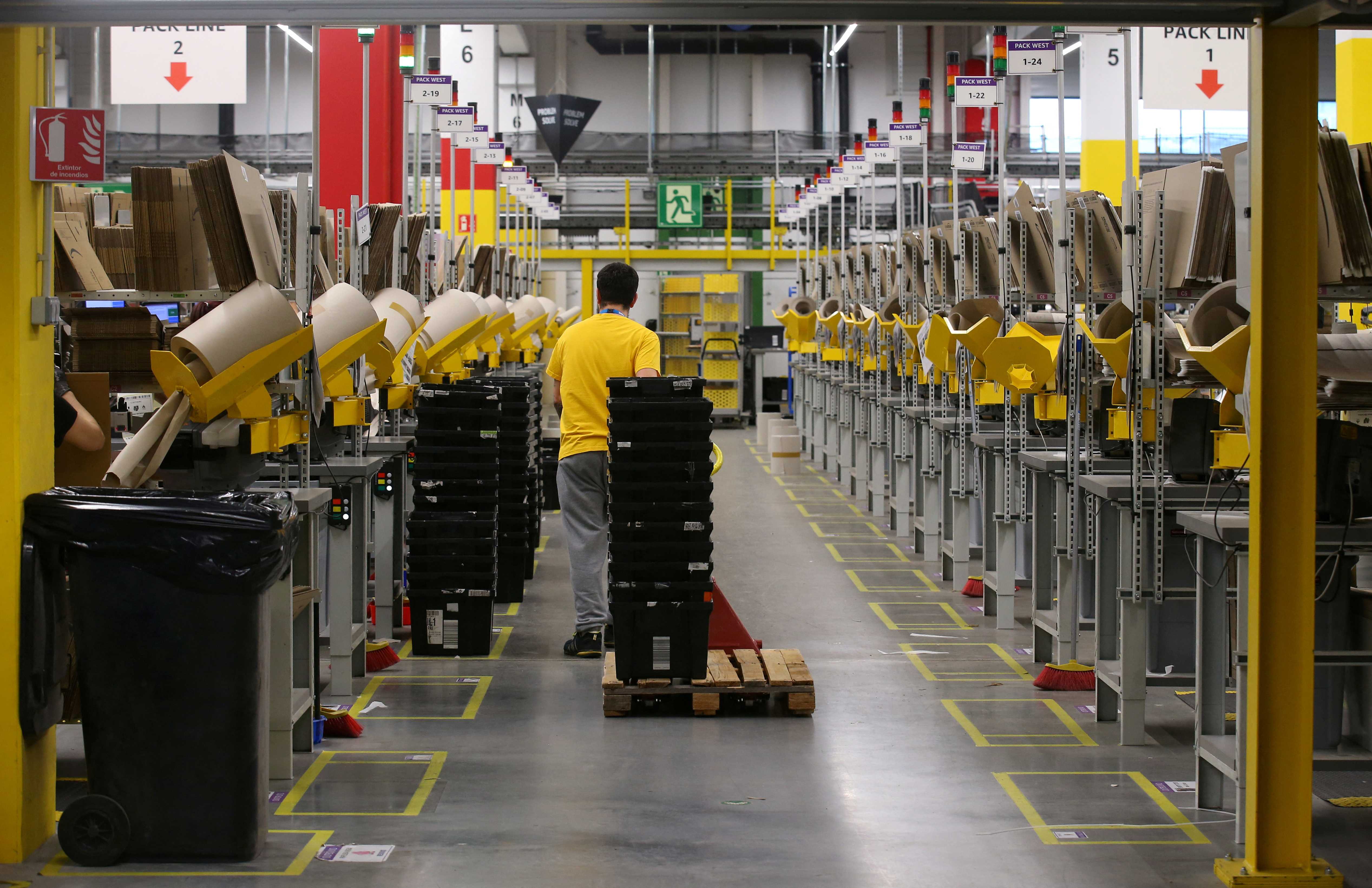 A worker moves boxes at a packaging area inside Amazon distribution center in El Prat de Llobregat