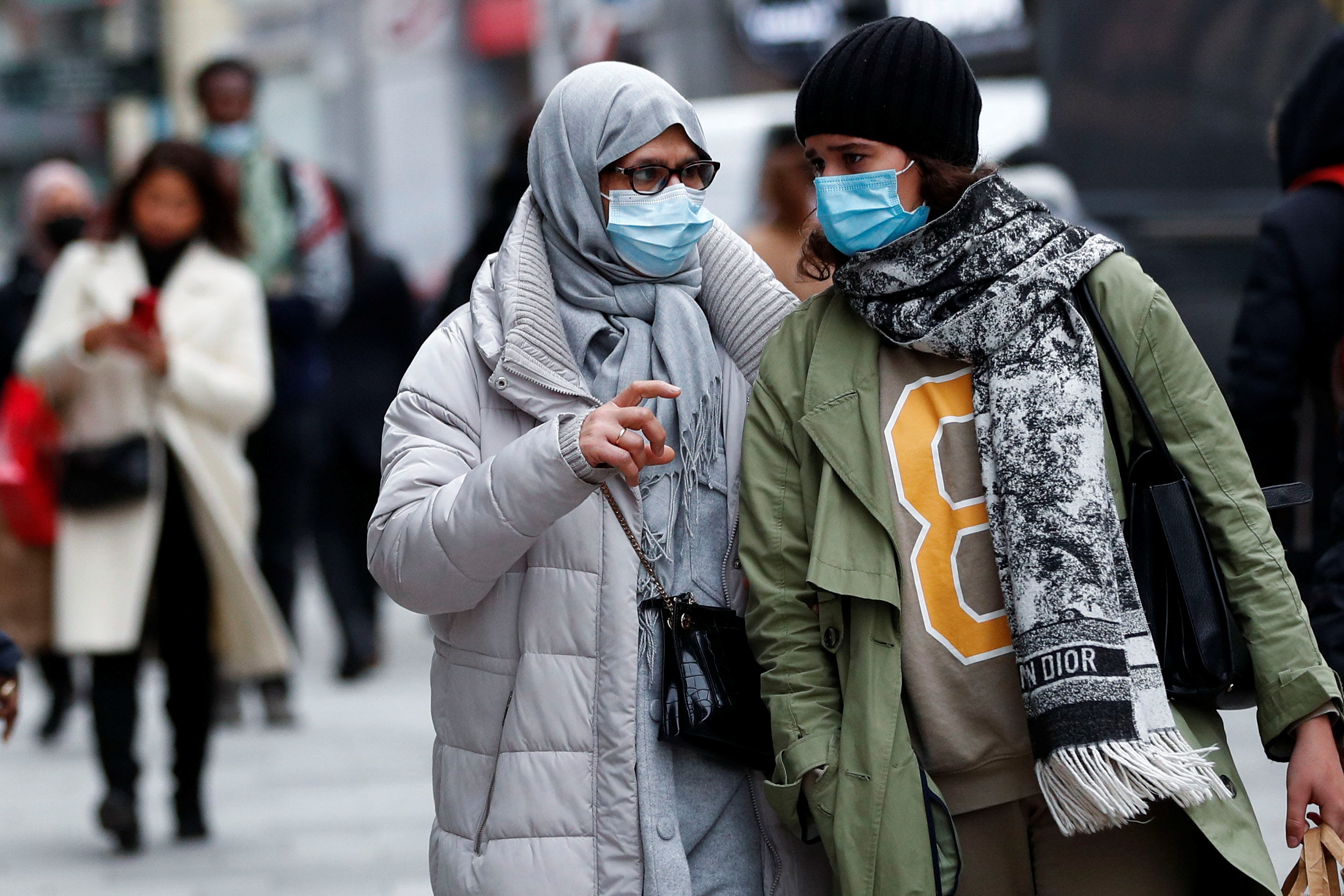 People wearing protective masks walk on a street, following the government's restrictions imposed to contain the spread of coronavirus disease (COVID-19) in Brussels, Belgium, December 3, 2021. REUTERS/ Johanna Geron