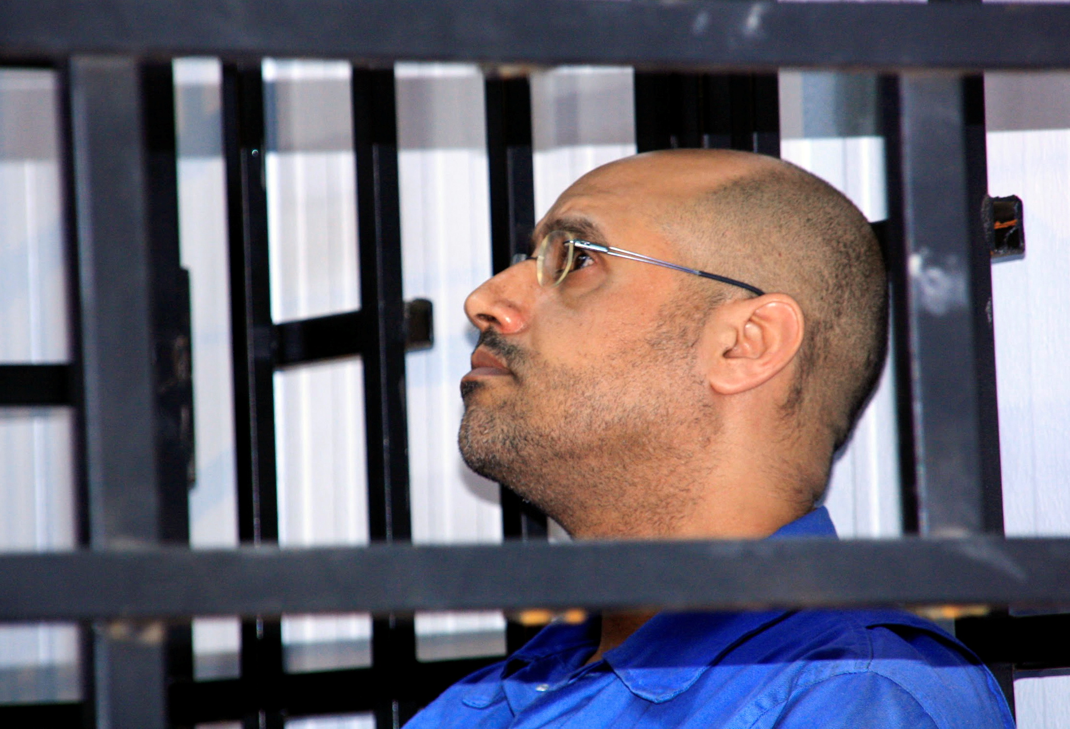 Saif al-Islam Gaddafi, son of late Libyan leader Muammar Gaddafi, attends a hearing behind bars in a courtroom in Zintan