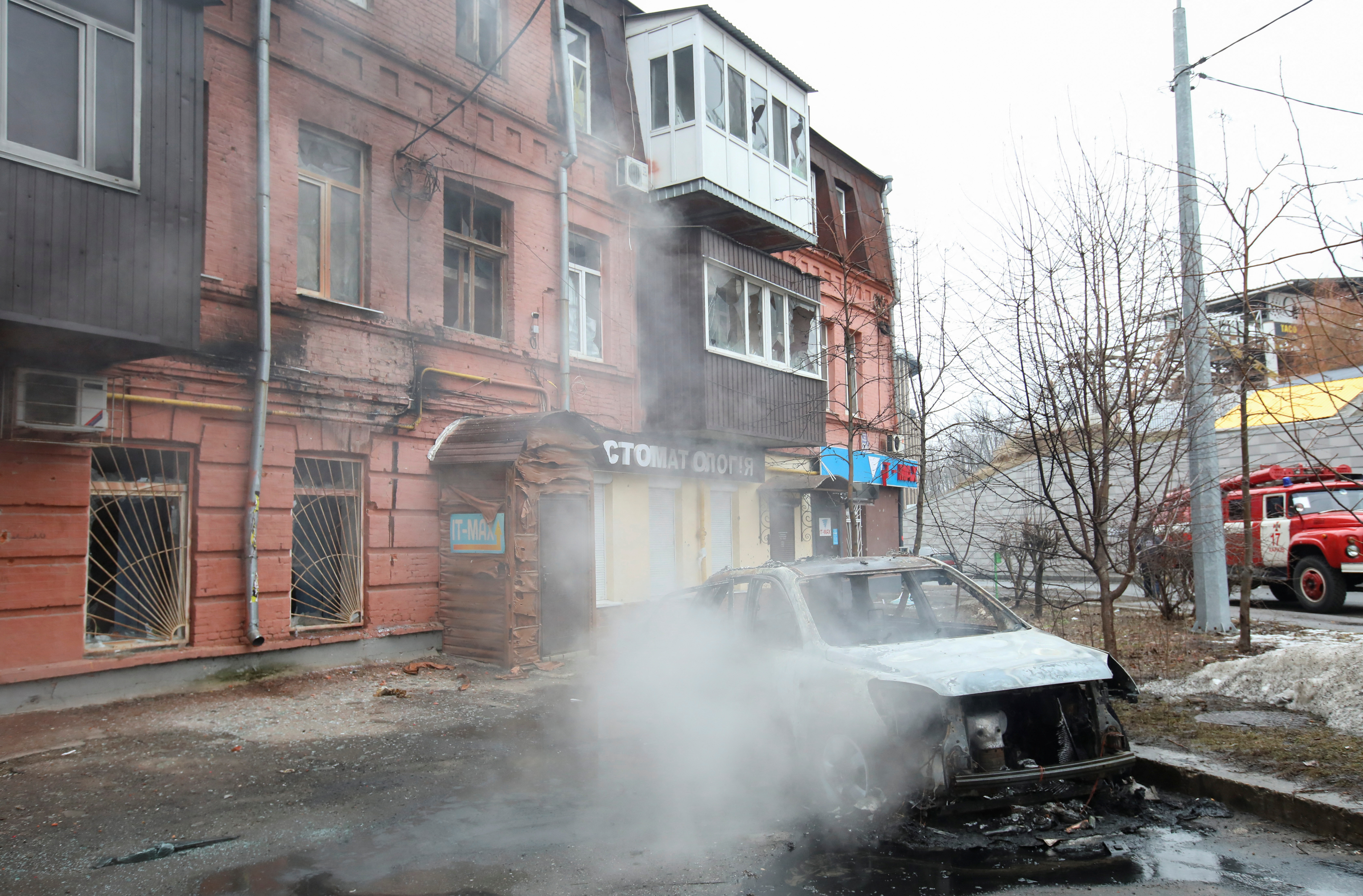 A view shows a burnt car in a street in Kharkiv