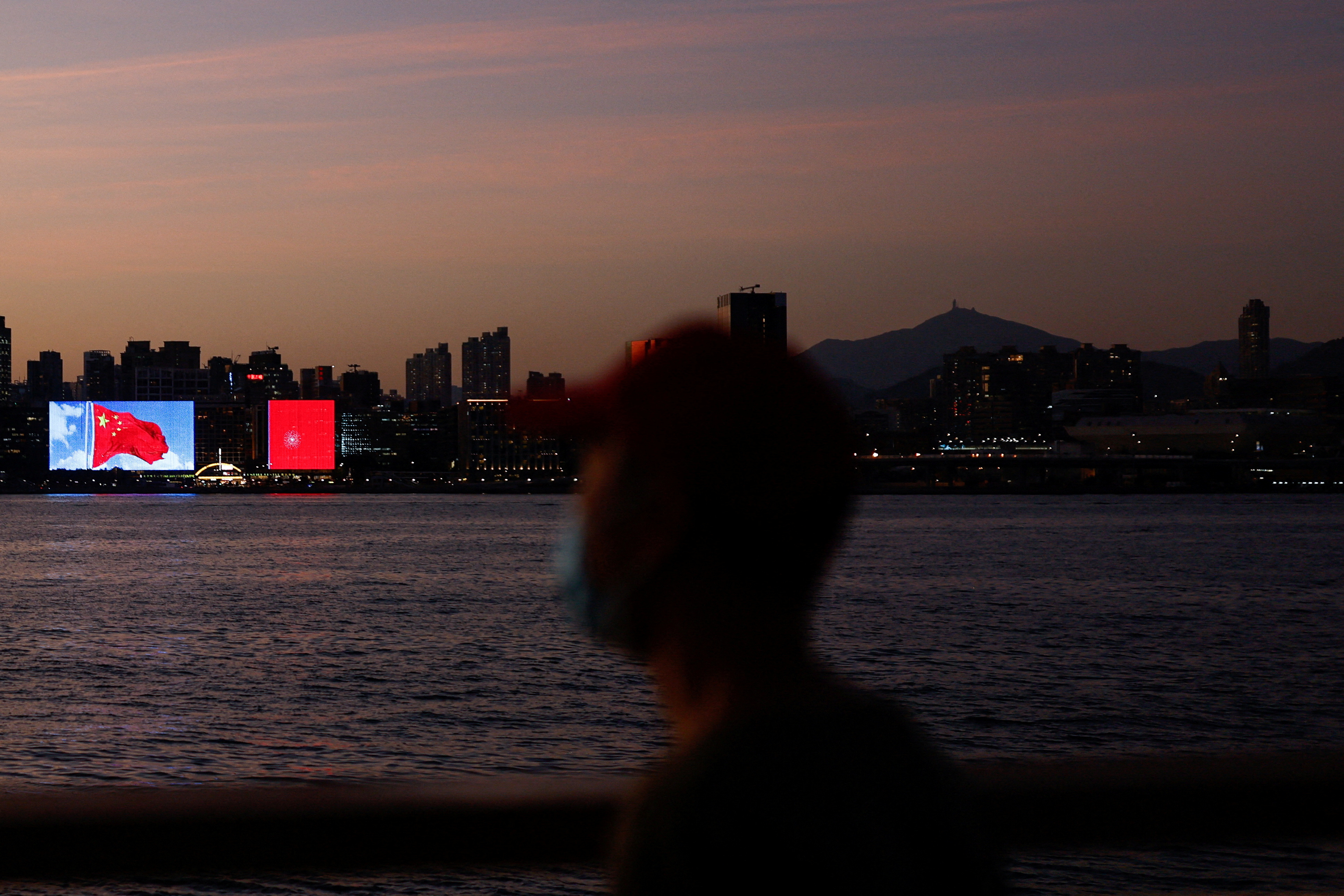 The Chinese flag is seen across the Victoria Harbour during sunset, in Hong Kong