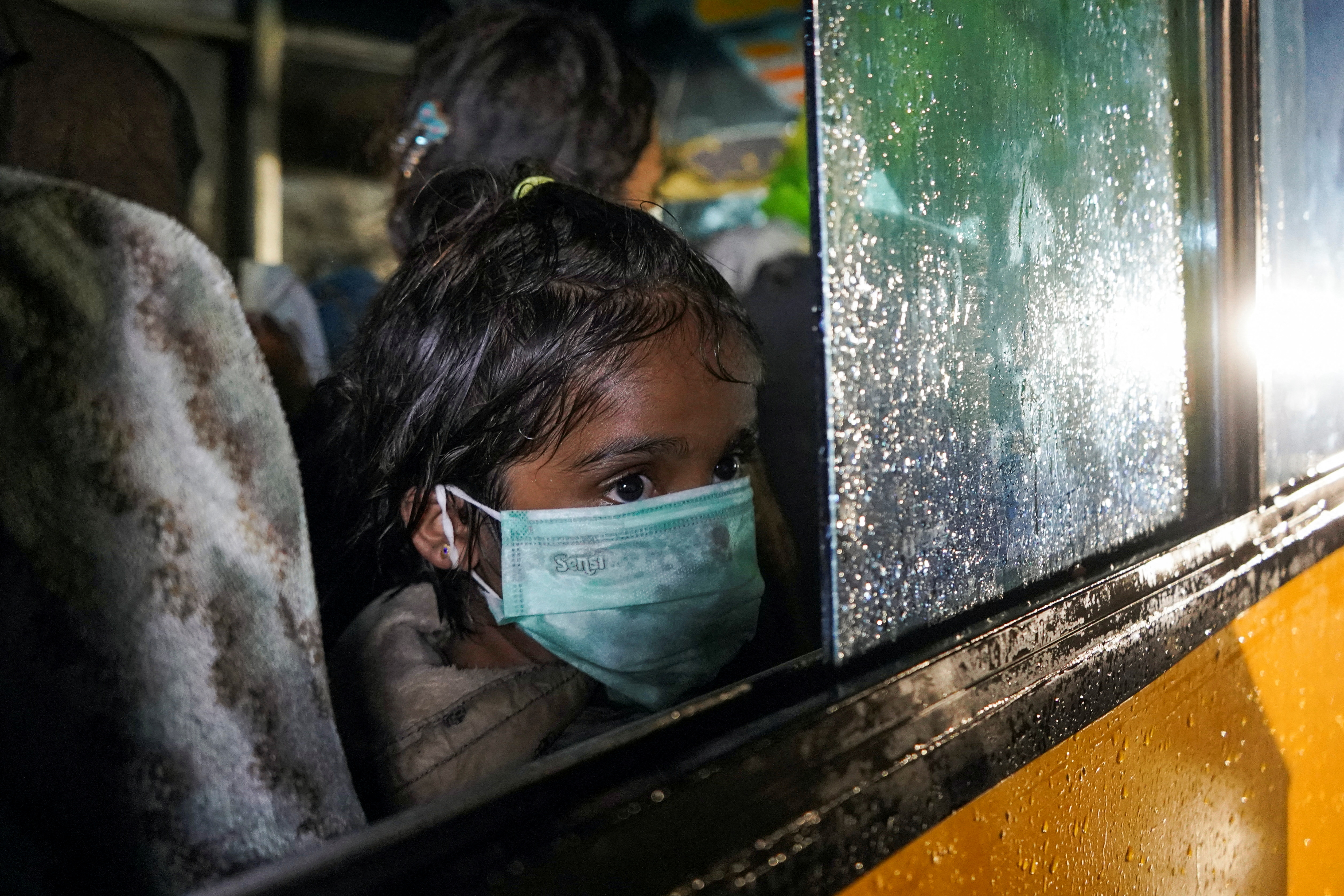 A Rohingya child looks on near a window of a bus during an evacuation after they arrive by boat at a port in Krueng Geukuh near Lhokseumawe, North Aceh