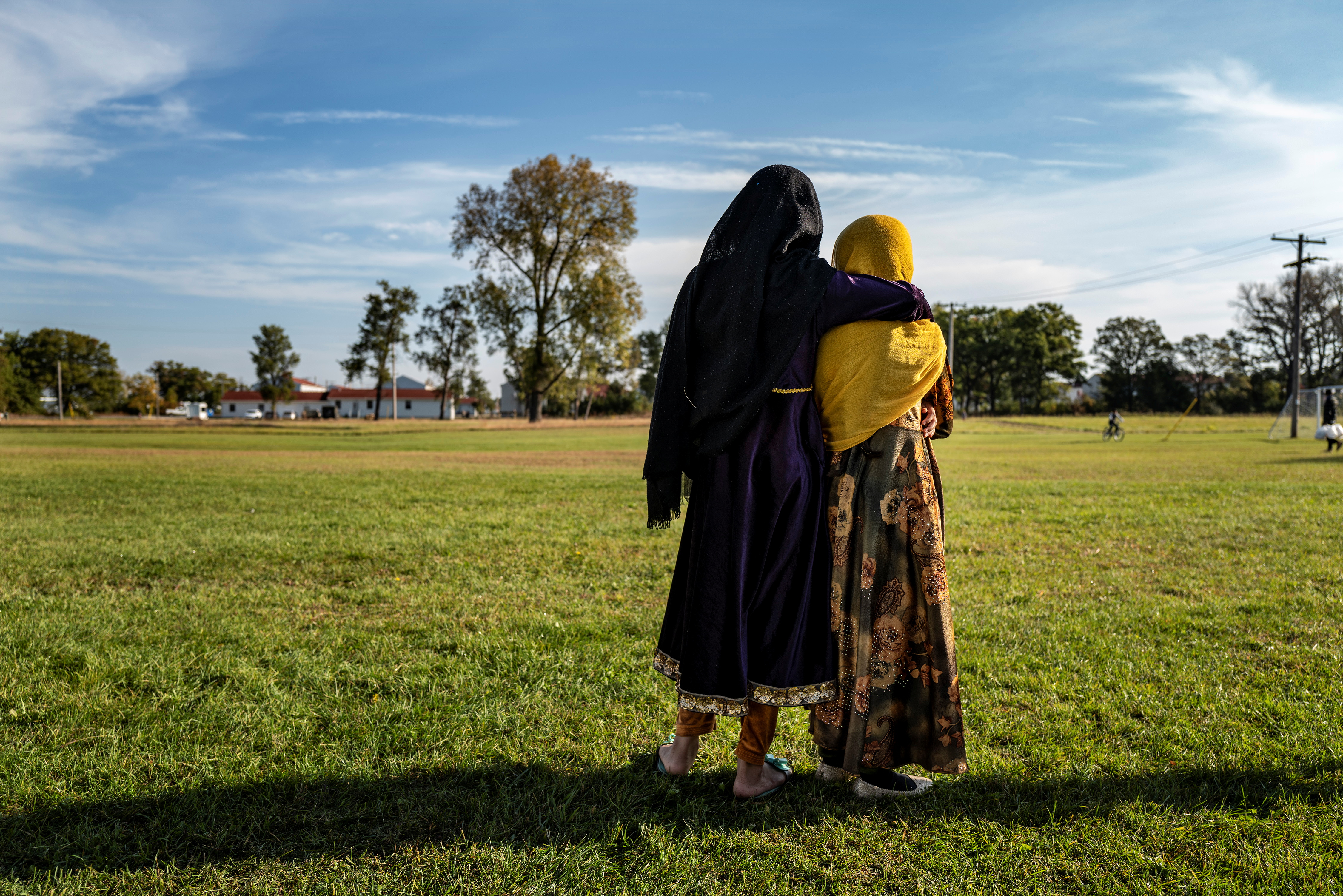 Afghan refugee girls watch a soccer match near where they are staying in the Village at the Fort McCoy U.S. Army base, in Fort McCoy, Wisconsin, U.S., September 30, 2021. Barbara Davidson/Pool via REUTERS