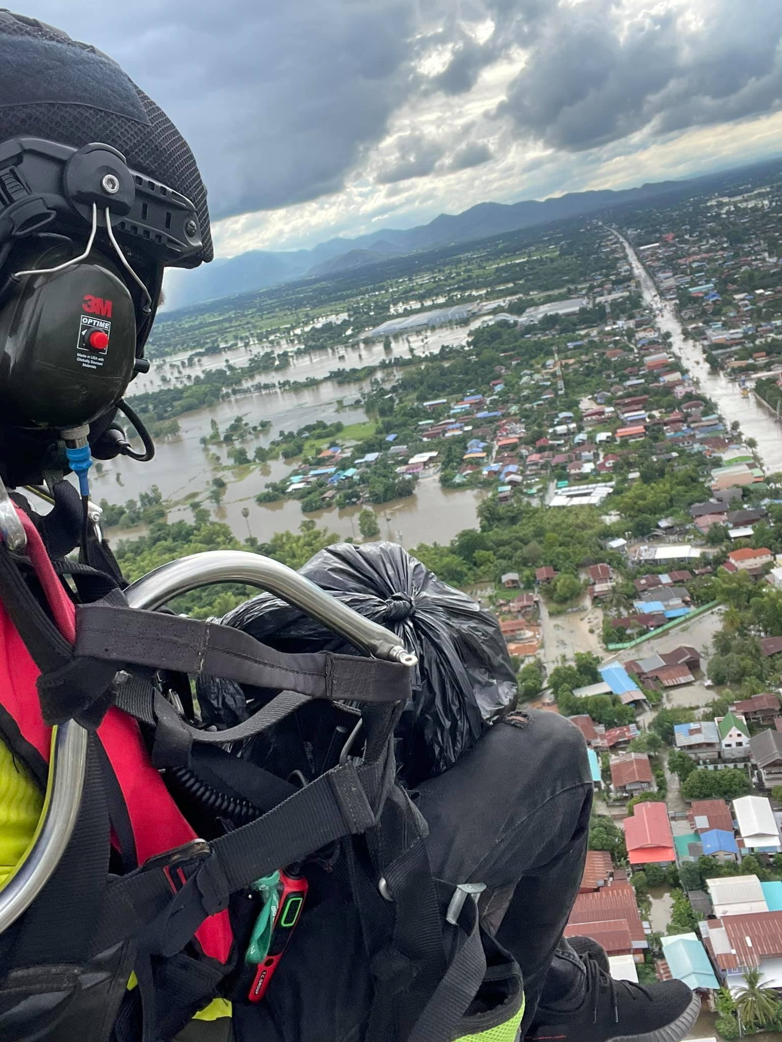 Powered paraglider delivers supplies to residents affected by flood in Sukhothai province, Thailand September 26, 2021 in this picture obtained from social media on September 28, 2021. The Charity Of Phitsanulok Association/via REUTERS 